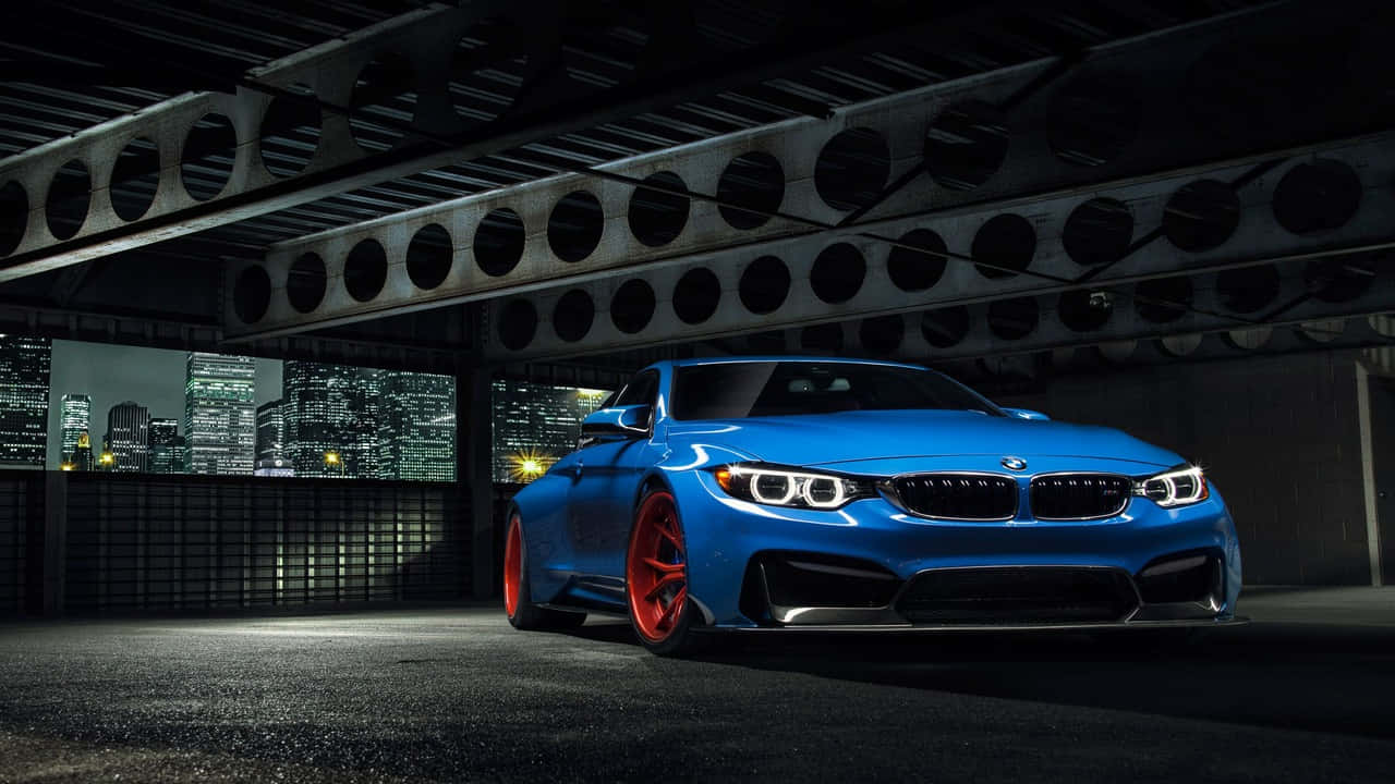 車輪上的奢華——駕馭BMW 壁紙 — 一輛鮮藍色BMW跑車配紅色輪圈，夜晚停泊在鋼橋下，背景城市燈光閃爍。