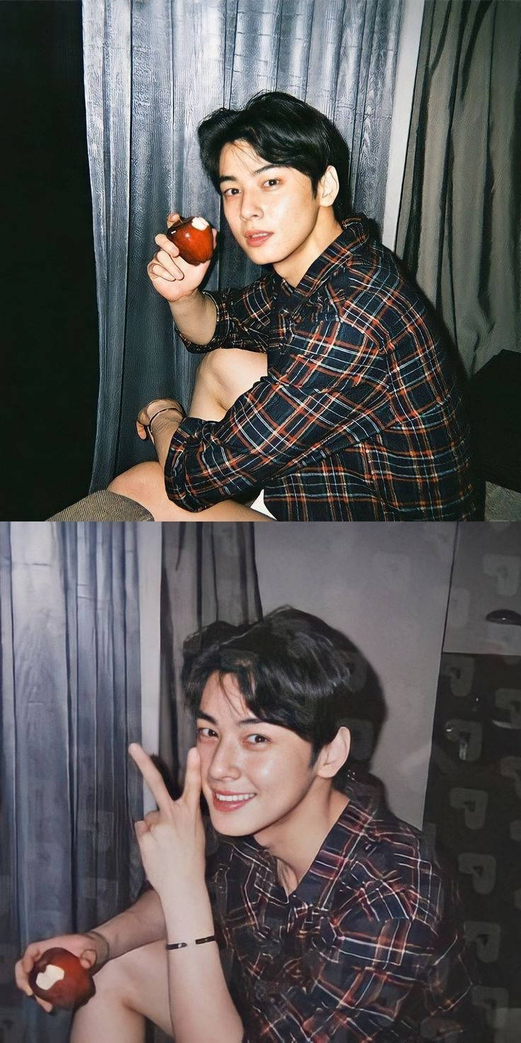 穿著格仔襯衫的年輕男子在窗簾前拿著蘋果微笑。