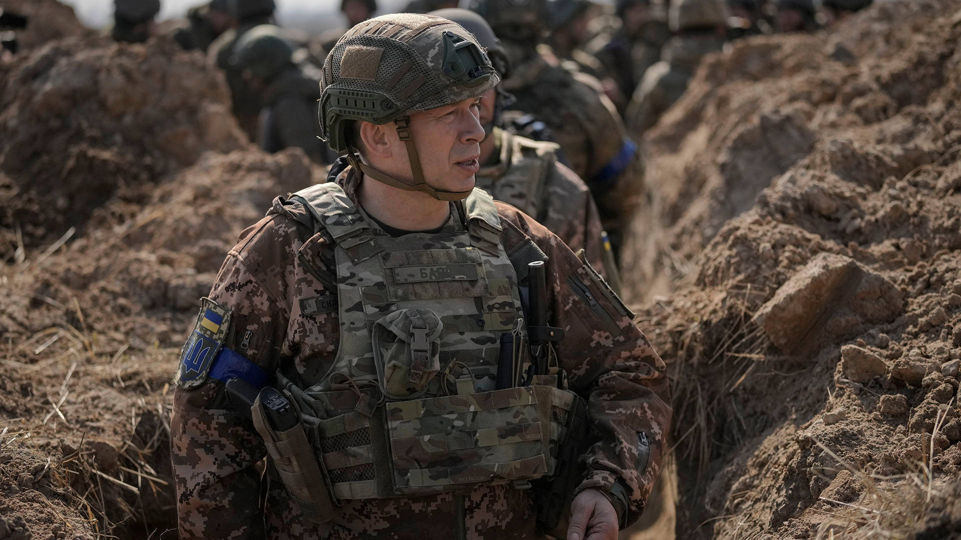軍事行動期間，一名身穿迷彩裝備的士兵站在泥濘的戰壕中。