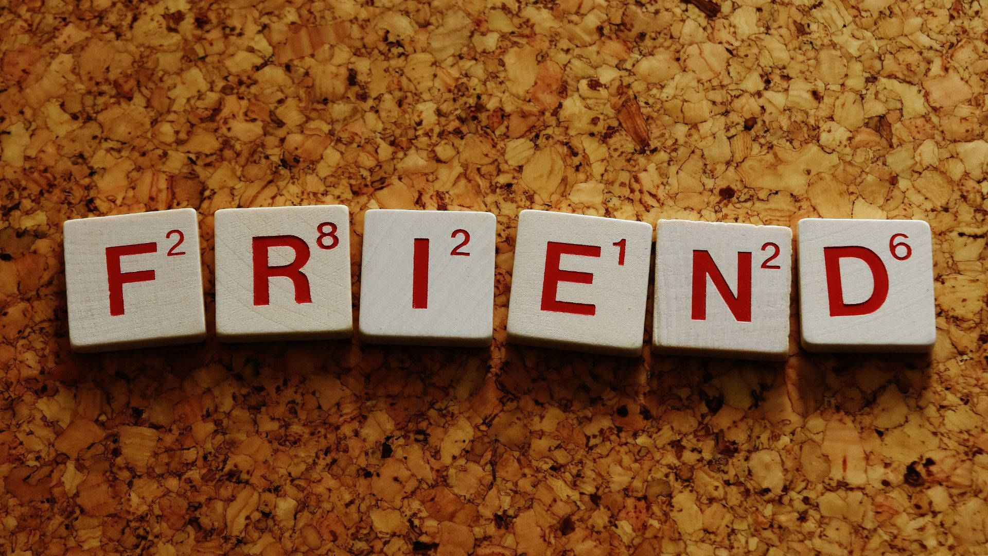 在軟木表面上拼出 FRIEND 的 Scrabble 字母磚。