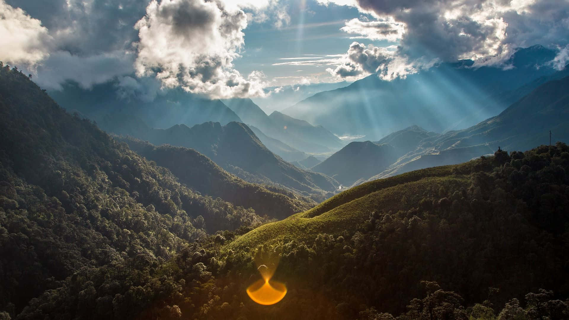 陽光穿透雲層，照耀在鬱鬱蔥蔥的山谷上。