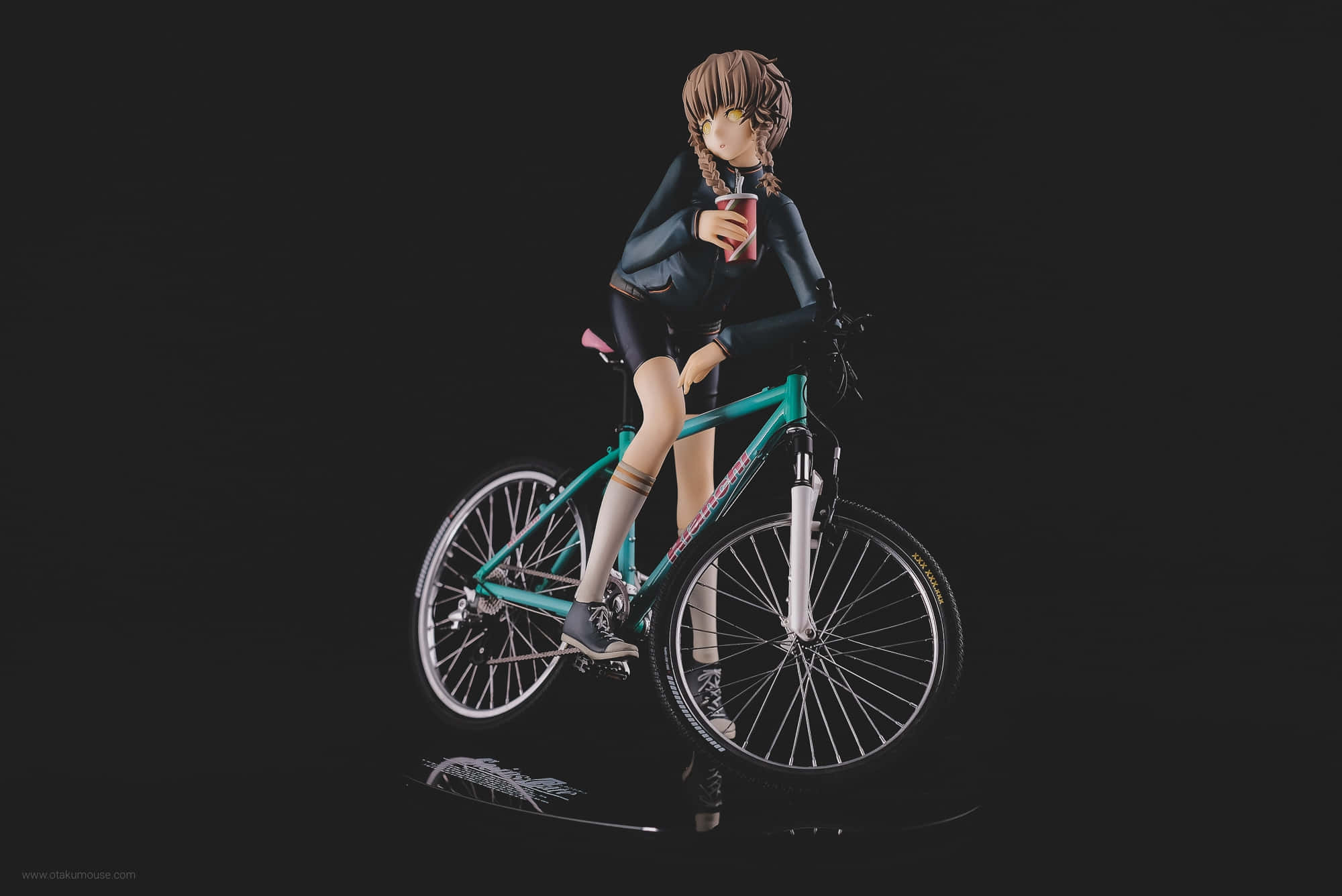 Suzuha Amane 桌布 壁紙 — 辮子動漫女孩公仔坐在青綠色單車上，手持紅色杯子，背景為黑色。