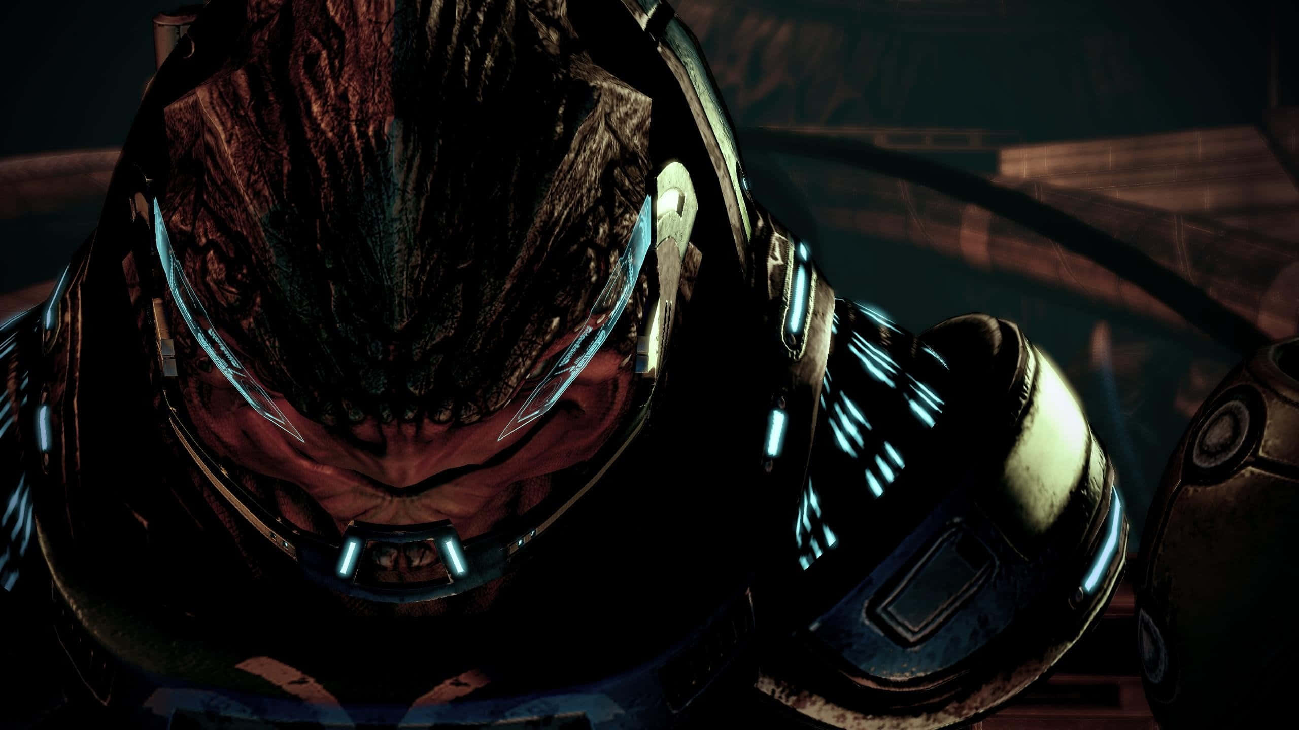 Mass Effect Grunt 桌布 壁紙 — 近距離拍攝一位身穿重甲、帶有發光藍色點綴和深色頭盔的戰士，處於昏暗的科幻場景中。