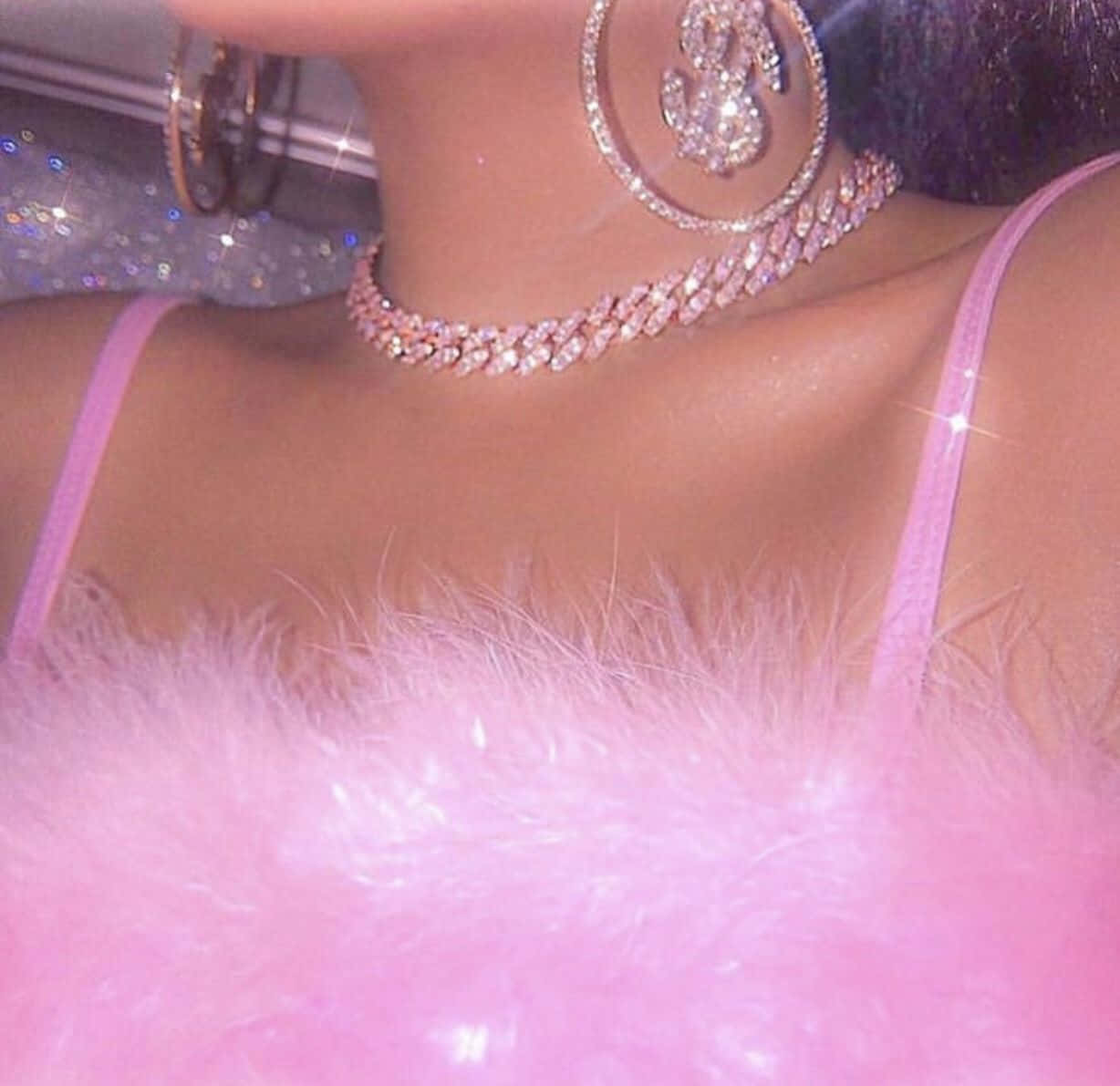 Baddie Vintage 90's Aesthetic 桌布 壁紙 — 近距離拍攝一個人穿著閃閃發光的粉紅色羽毛上衣和鑲有鑽石的美元符號耳環。