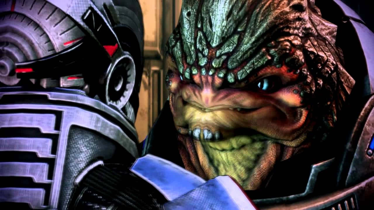 Mass Effect Grunt 桌布 壁紙 — 近距離拍攝一個帶有紋理綠色皮膚和發光藍色眼睛的威脅性外星人，在昏暗燈光下與機械臂對峙。