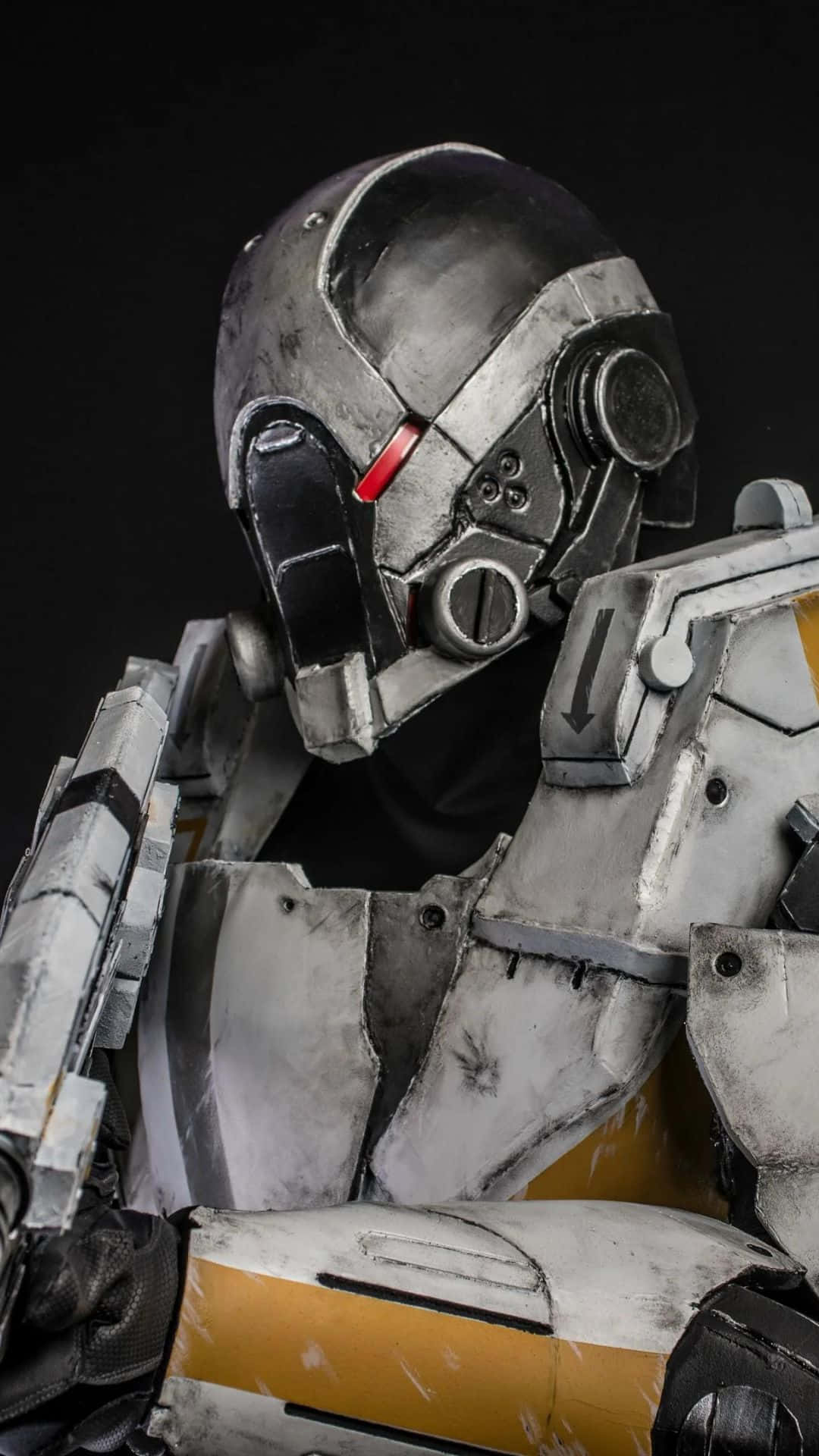 Mass Effect Cerberus 桌布 壁紙 — 近距離拍攝一個細節豐富的未來風格裝甲服，頭盔上有一個發光的紅色眼睛，背景為黑色。