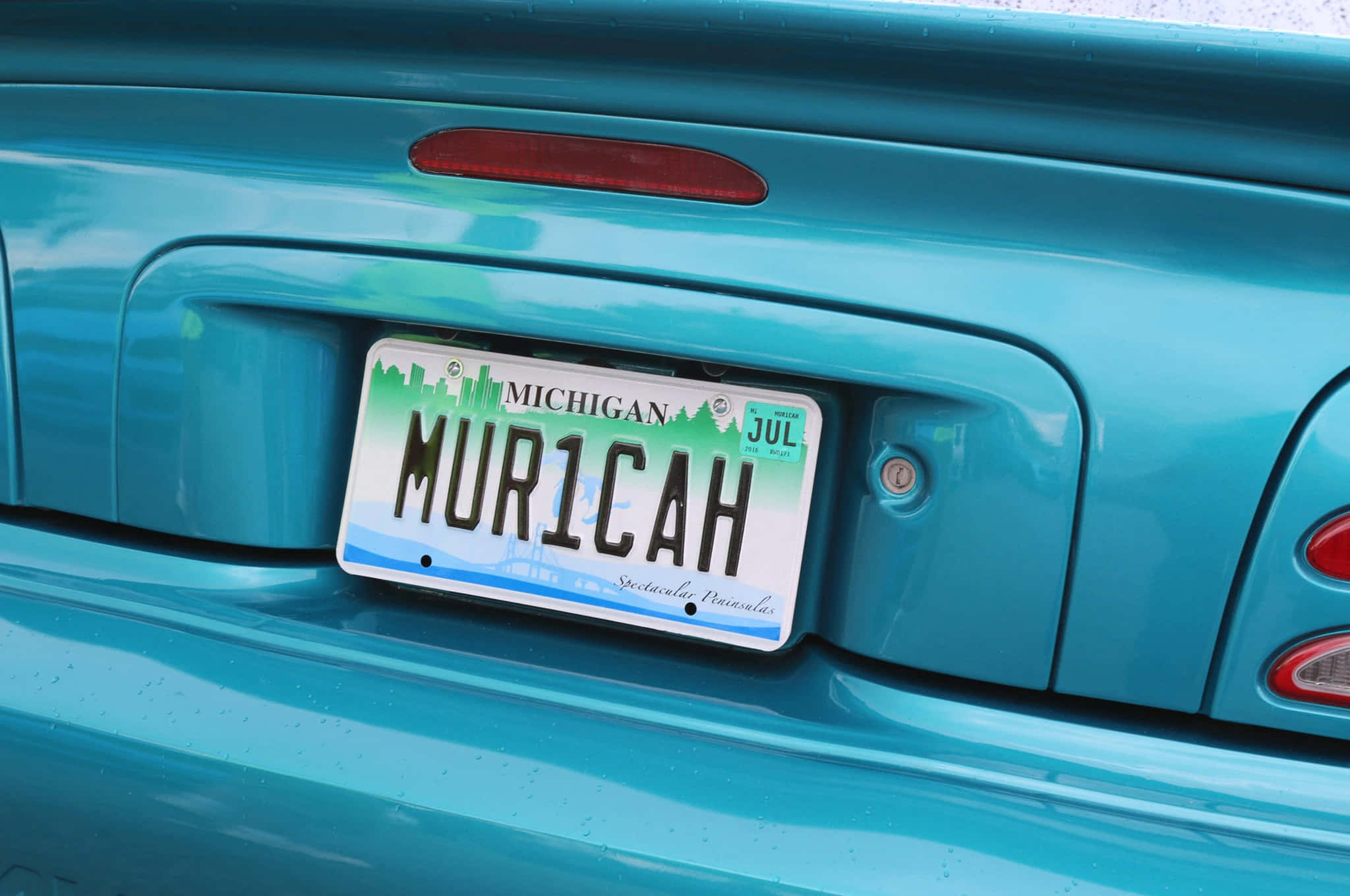 Car License Plate 桌布 壁紙 — 近距離拍攝一輛青綠色汽車的尾部，帶有密歇根州車牌，個人化文字為MUR1CAH。