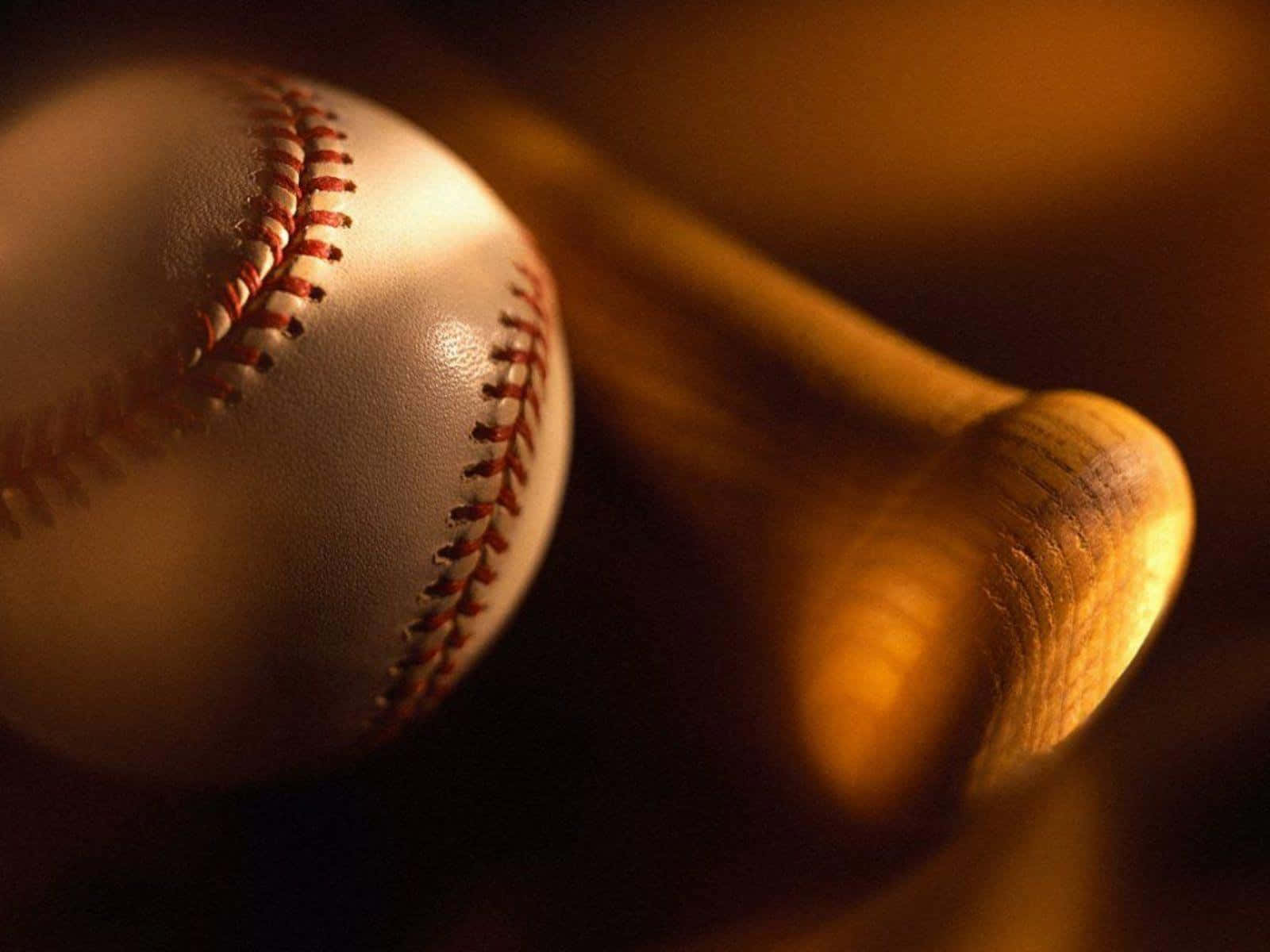 Softball 桌布 壁紙 — 近距離拍攝棒球和木製球棒，沐浴在溫暖的金色光線中，景深較淺。