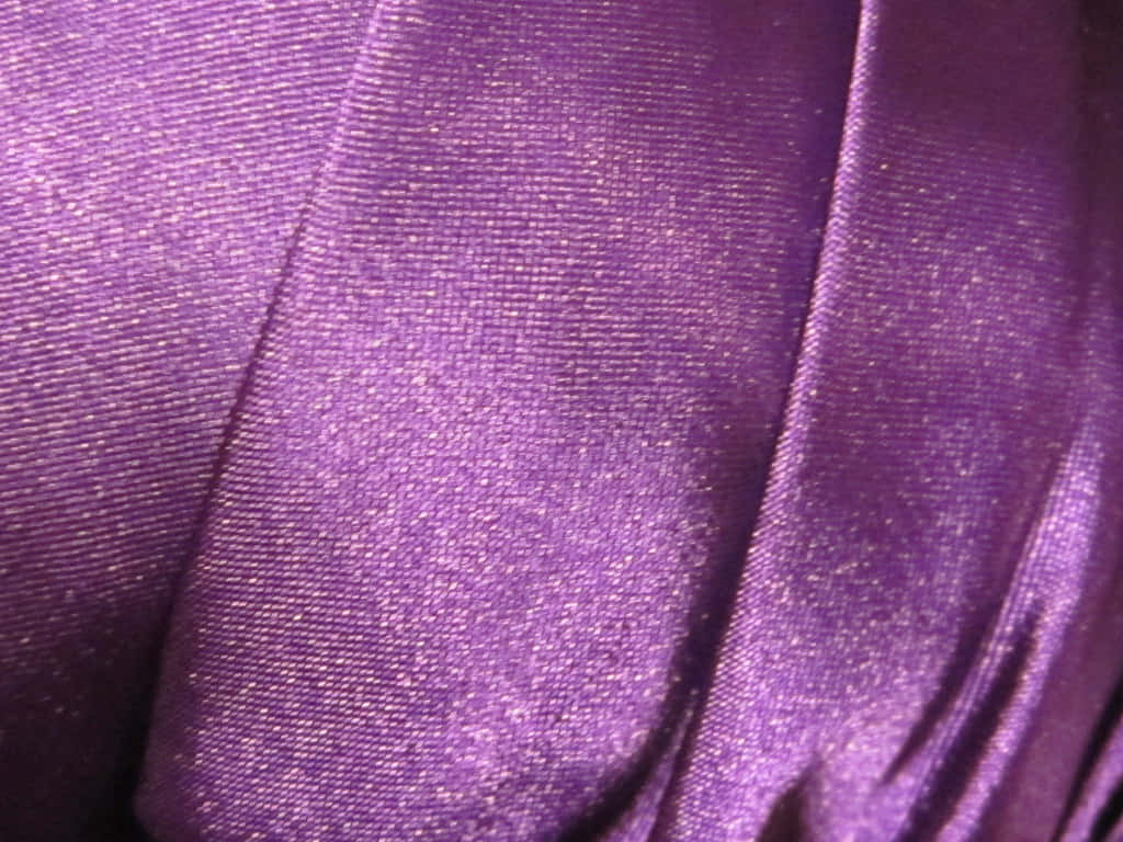 Purple Satin 桌布 壁紙 — 近距離拍攝的豐富紫色布料，帶有細微閃粉和柔軟褶皺，捕捉光線。