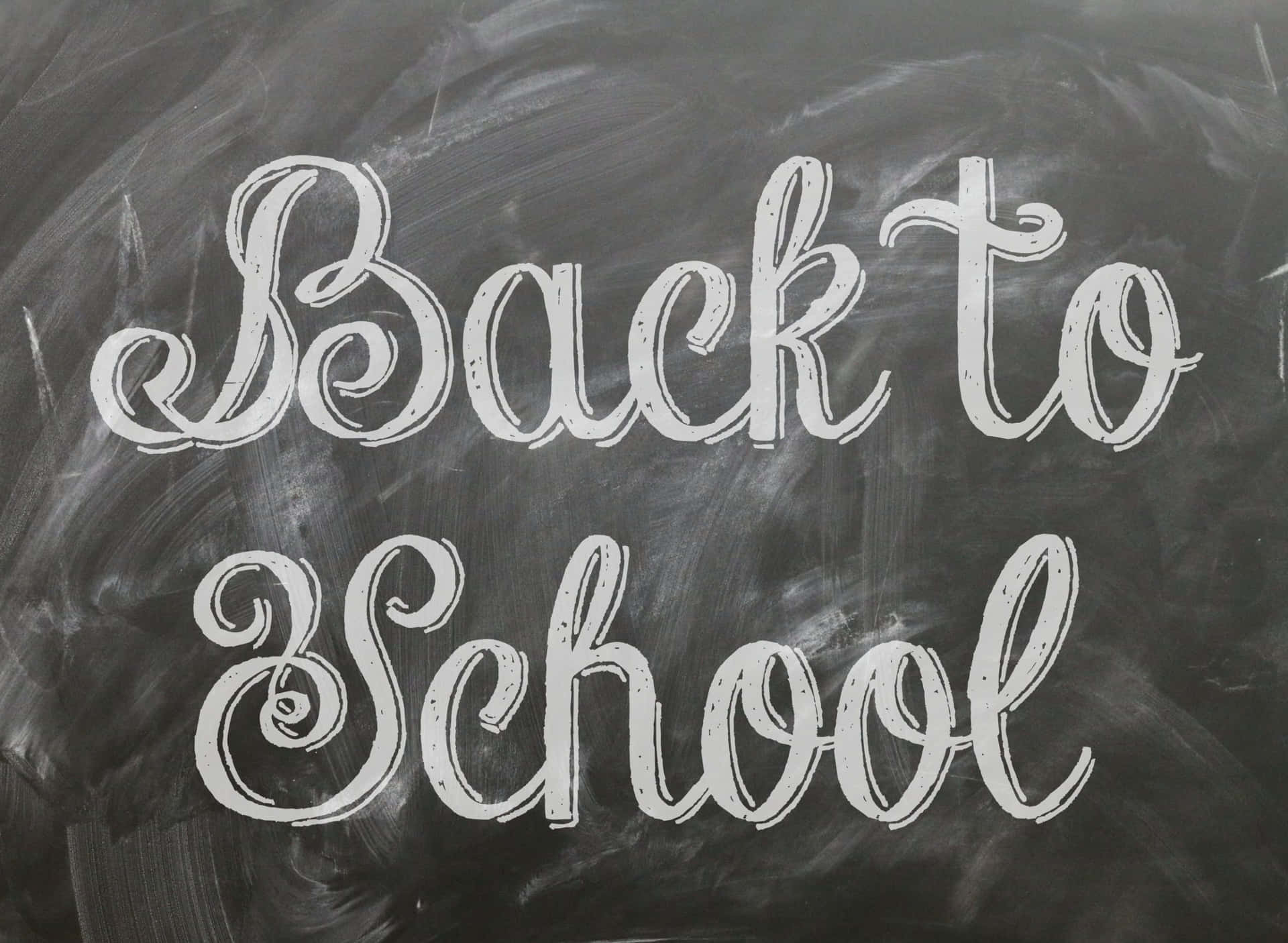 黑板上用白色草書寫著「Back to School」。