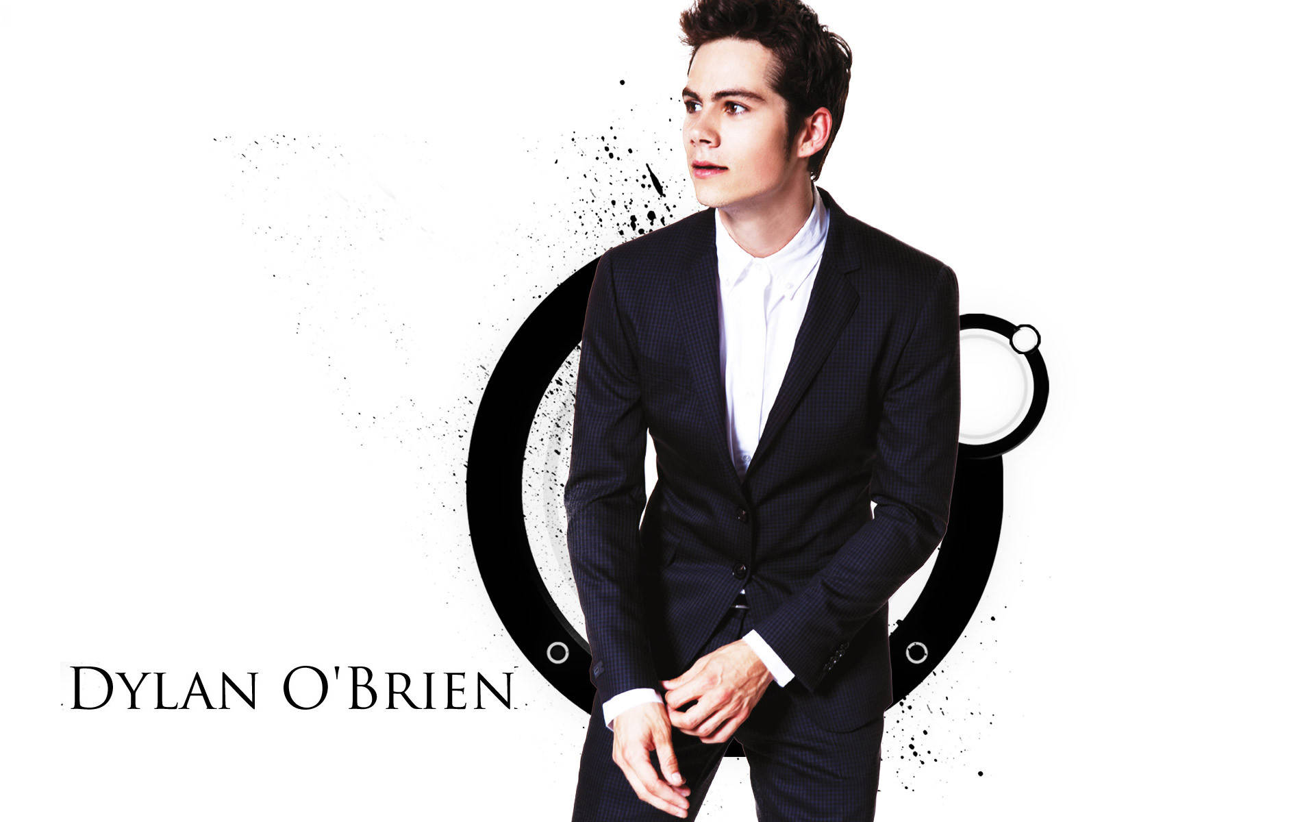 Dylan O'Brien 身穿深色西裝，身後有風格化的黑色圓形設計，擺出姿勢。