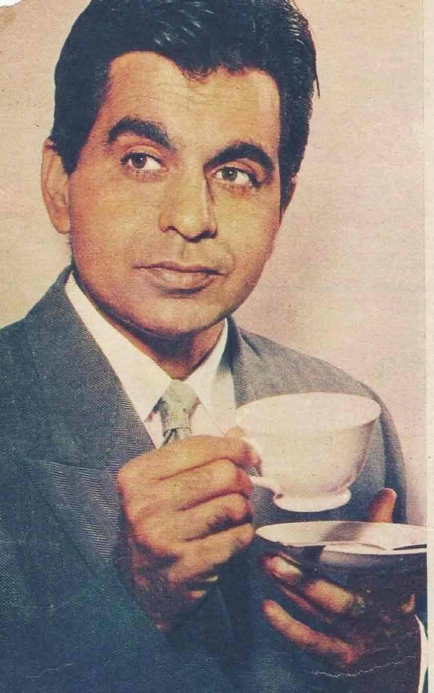 穿著西裝的男人拿著茶杯，表情深思。