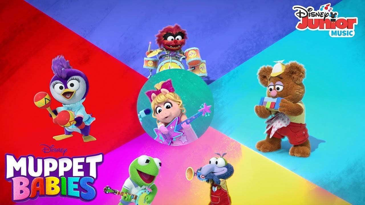 迪士尼小木偶寶寶音樂樂隊 壁紙 — 色彩繽紛的Muppet Babies角色在彩色幾何背景前演奏樂器。