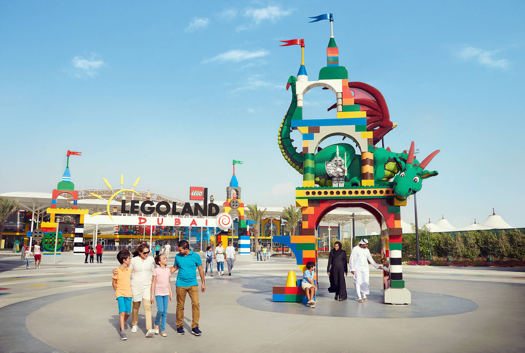 家庭在LEGOLAND Dubai一個巨大的LEGO龍拱門附近行走。
