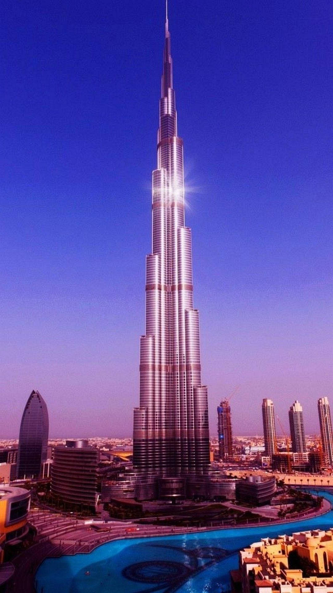迪拜閃耀建築 壁紙 — 哈利法塔在深藍色暮色天空下，伴隨著耀眼的太陽光暈，聳立在杜拜的天際線上。