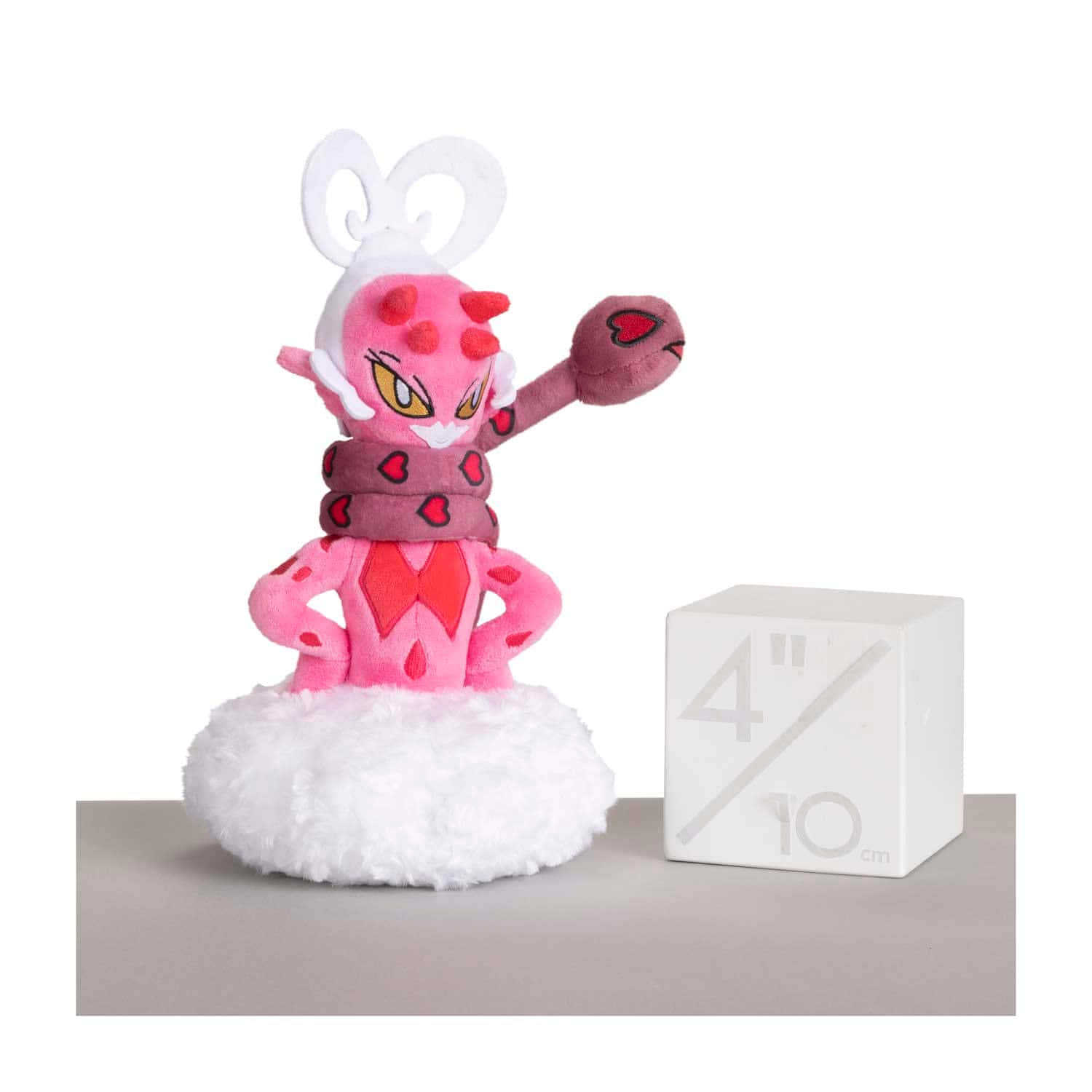 迷人 Enamorus 毛絨玩具 壁紙 — 一隻粉紅色的 Pokémon Clefable 毛絨玩具在白色絨毛底座上自信地擺姿勢，旁邊有一個白色比例立方體。
