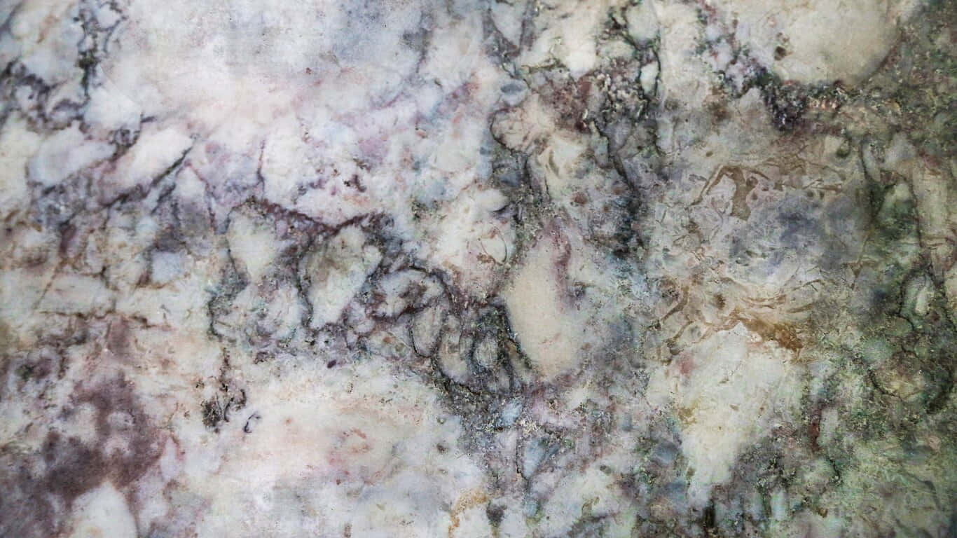 大理石表面的特寫，帶有灰色、紫色和綠色的漩渦紋理。