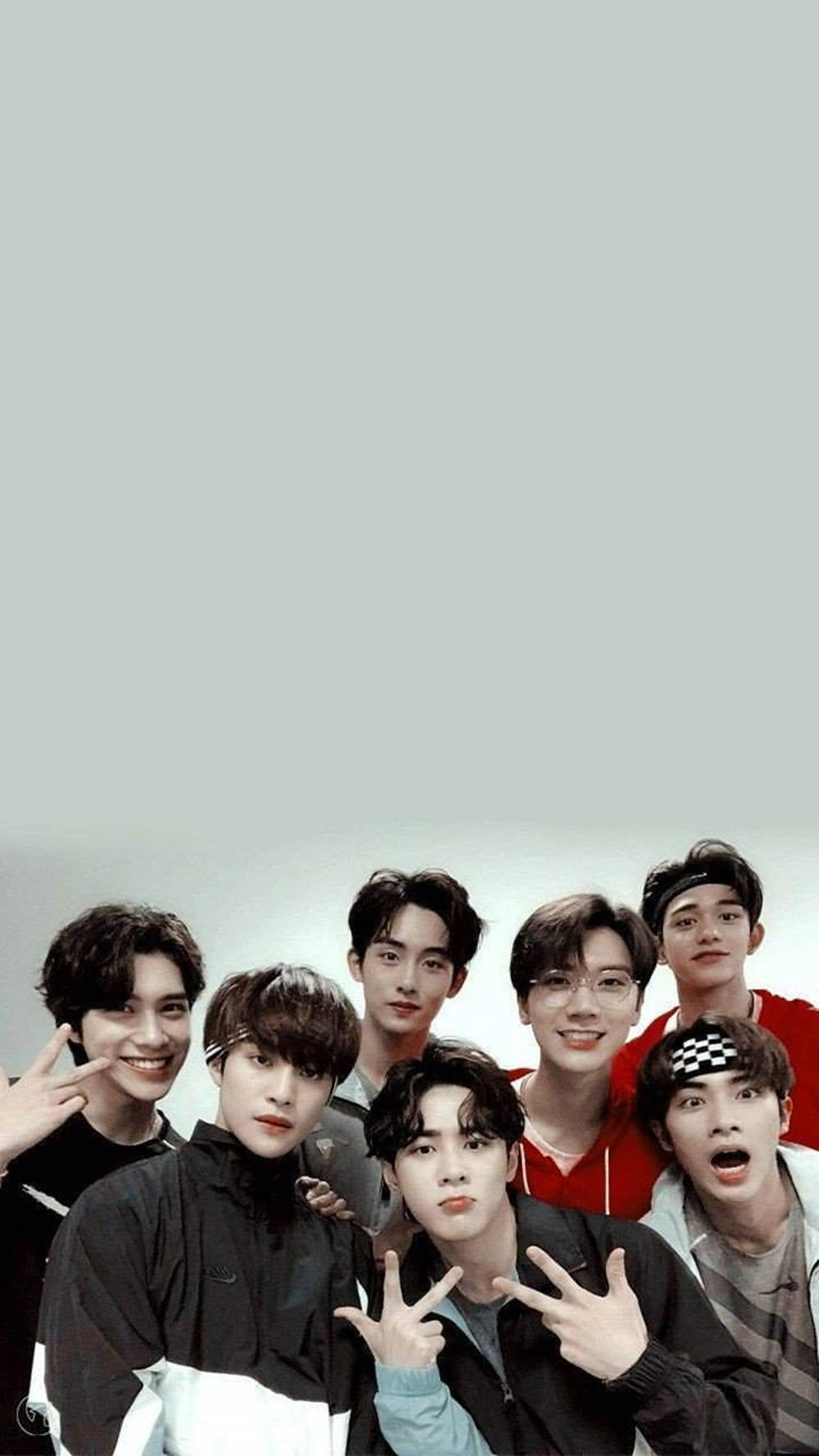 迷人BTS手機主題 壁紙 — 七位年輕男士身穿休閒服裝，在純淺灰色背景前愉快地擺姿勢，做出俏皮的手勢。