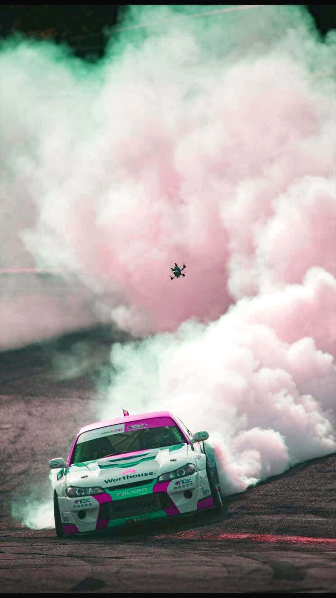 飄移車在賽道上製造粉紅色煙霧，無人機在上空飛過