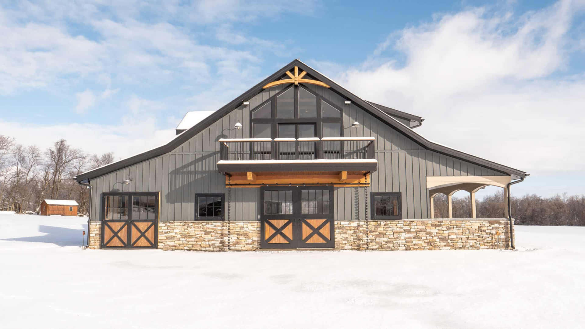 冬季田野中的現代穀倉，石頭地基，屋頂積雪。