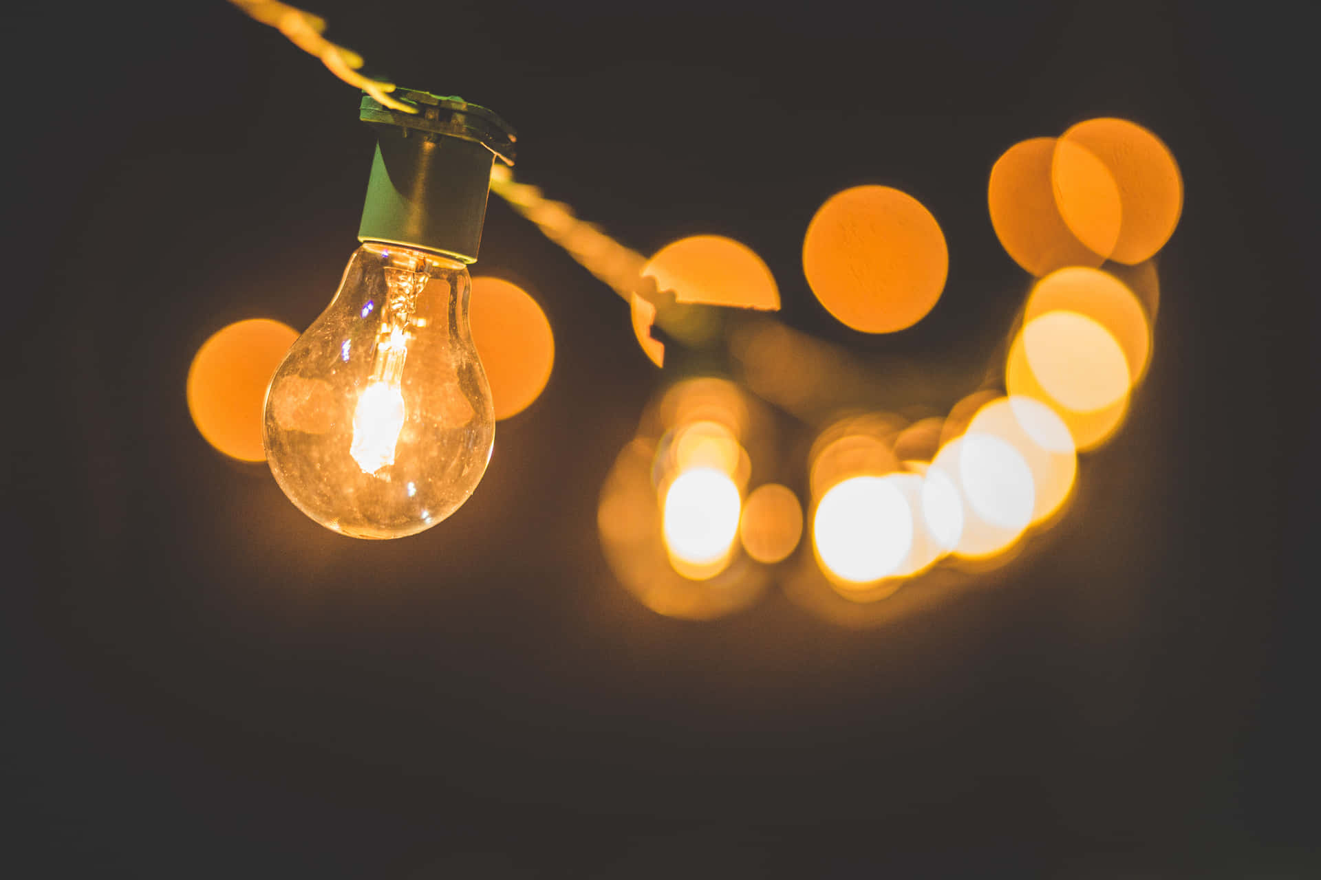 一串發光的戶外燈飾，其中一顆燈泡清晰對焦。