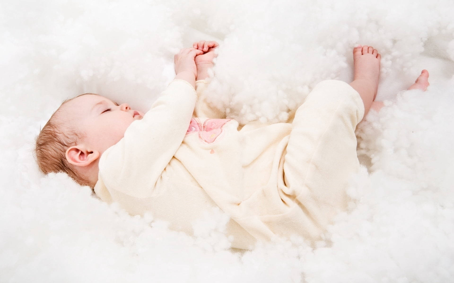 一個睡在蓬鬆白色雲朵床上的嬰兒