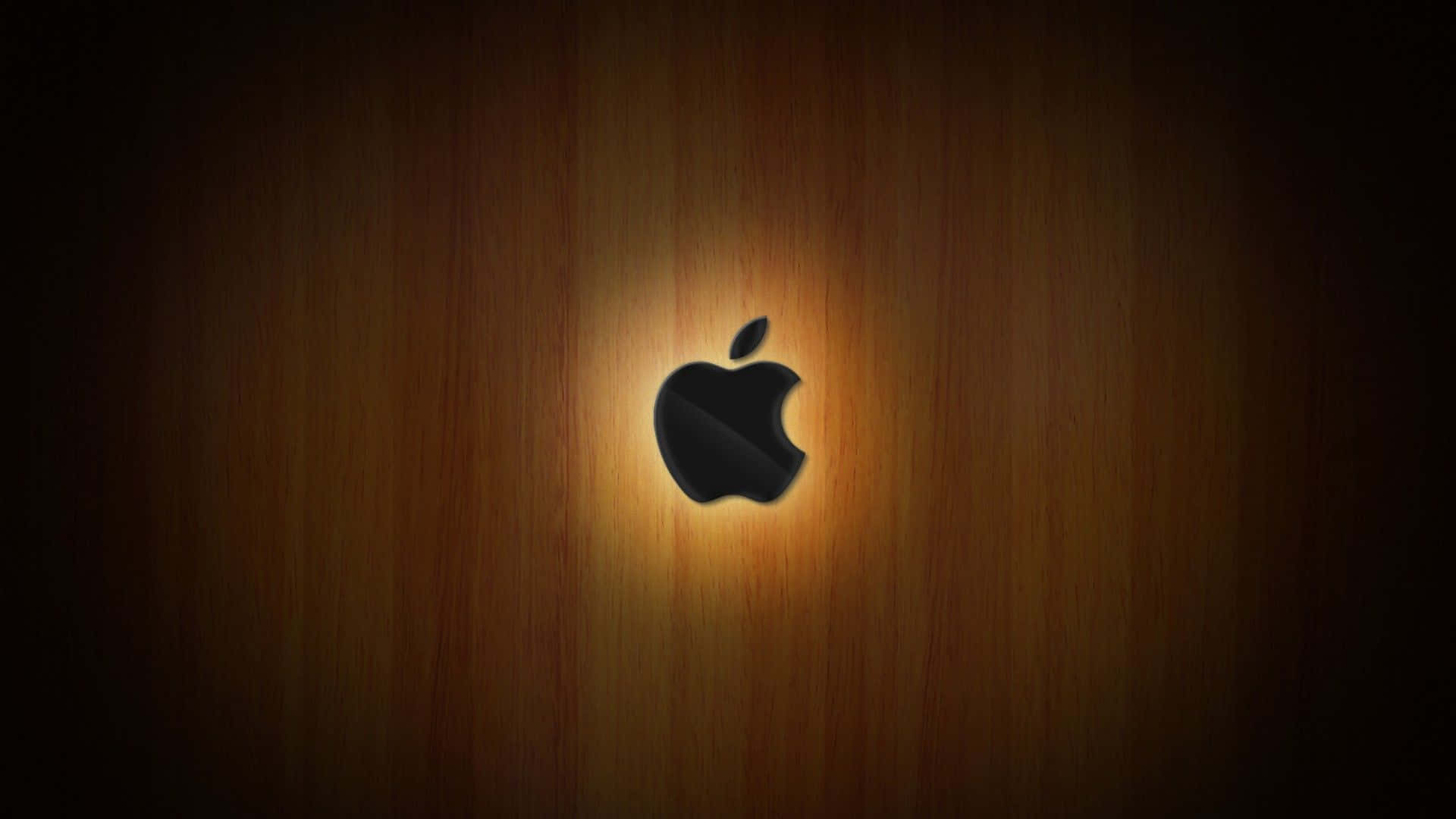 黑色Apple標誌在木質表面上柔和照明下發光。