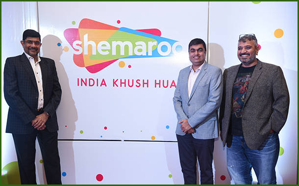 三位男士在Shemaroo India Khush Hua活動中，背後有色彩繽紛的品牌標誌，正在擺姿勢。