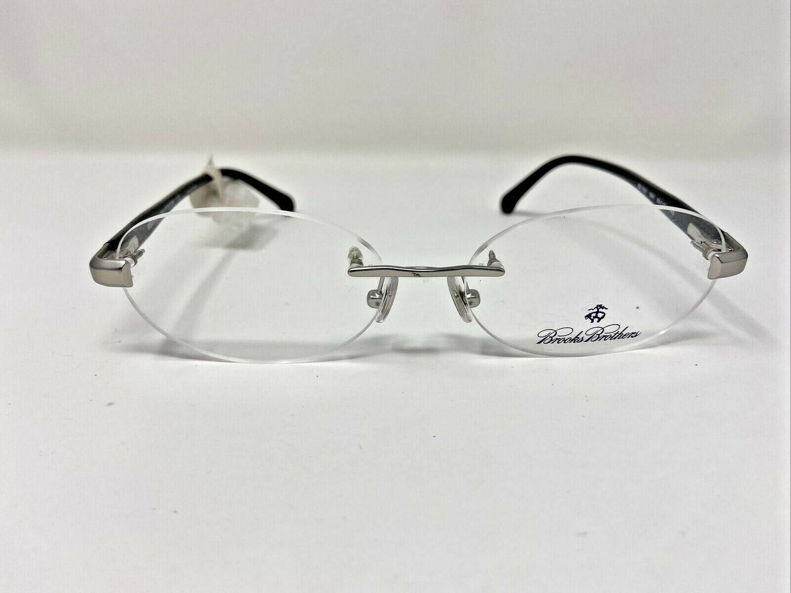 迷人布魯克斯兄弟 BB398 男士銀色眼鏡 壁紙 — 一副Brooks Brothers無框眼鏡，帶有銀色金屬鼻橋和黑色鏡腿，放置在純白色表面上。