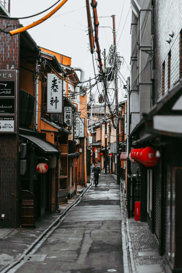 京都一條狹窄的雨巷，有傳統木建築和紅燈籠。