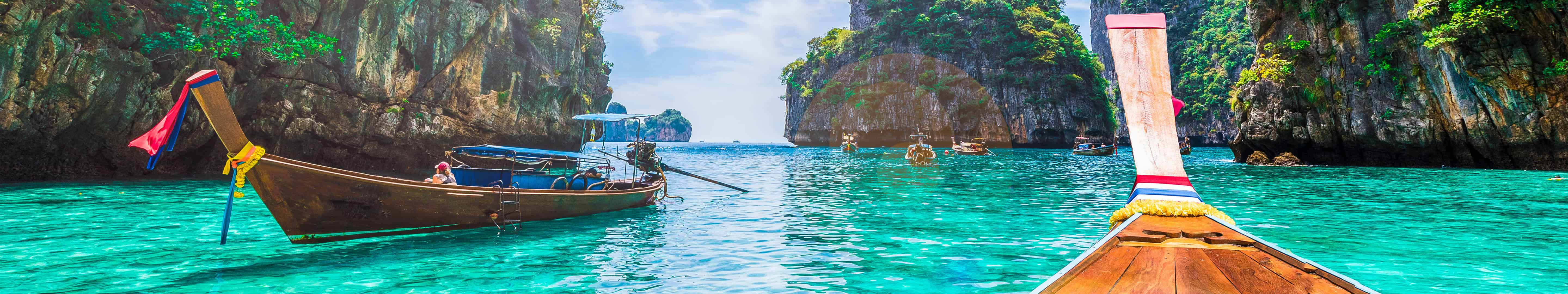 長尾船在碧綠潟湖中，四周環繞叢林懸崖