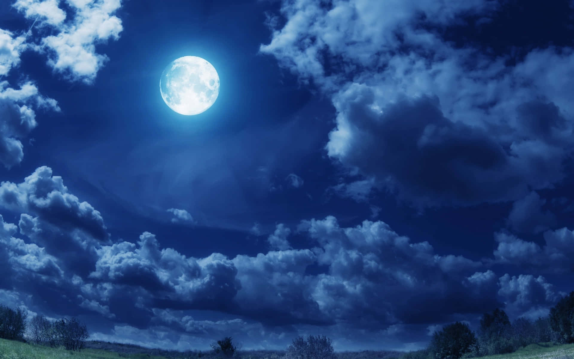 滿月穿過雲層照耀在夜晚的黑暗景觀上。