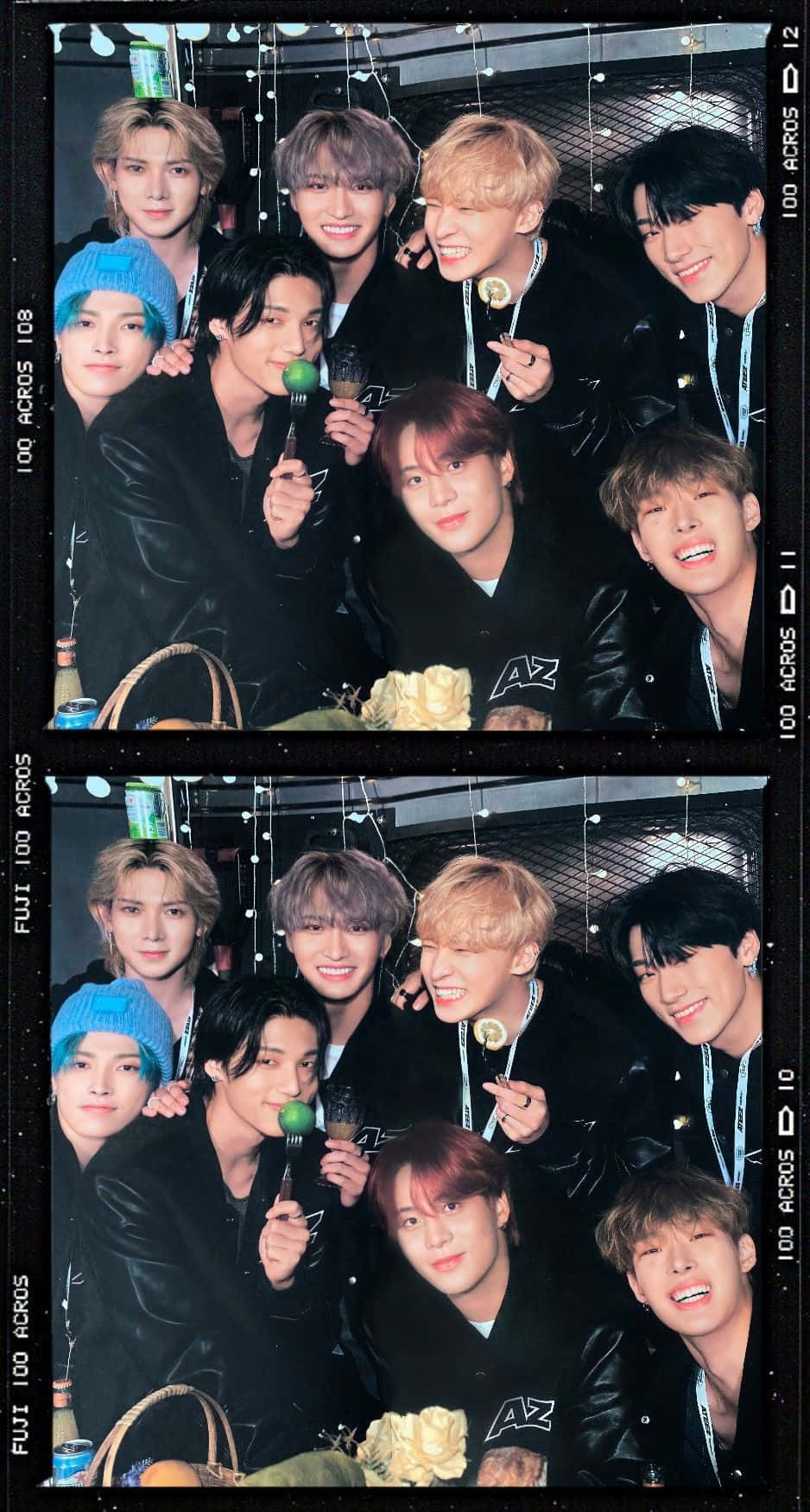 迷人的 K-pop 偶像登台演出 壁紙 — 一群身穿黑色皮褸的年輕男子在昏暗的室內環境中，掛著燈串和飲品，愉快地擺姿勢。