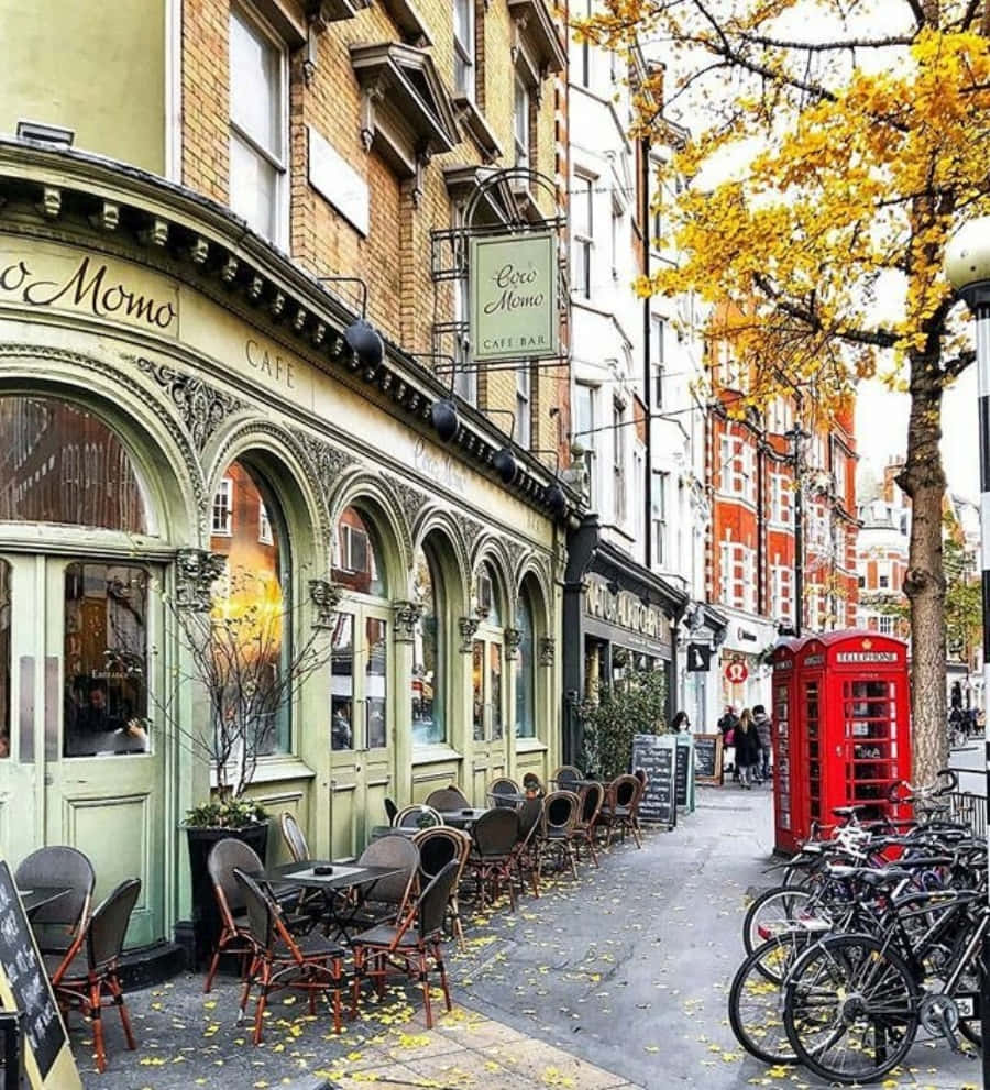 England 桌布 壁紙 — 迷人的秋日街景，設有復古咖啡館、紅色電話亭和金色樹葉下的單車。