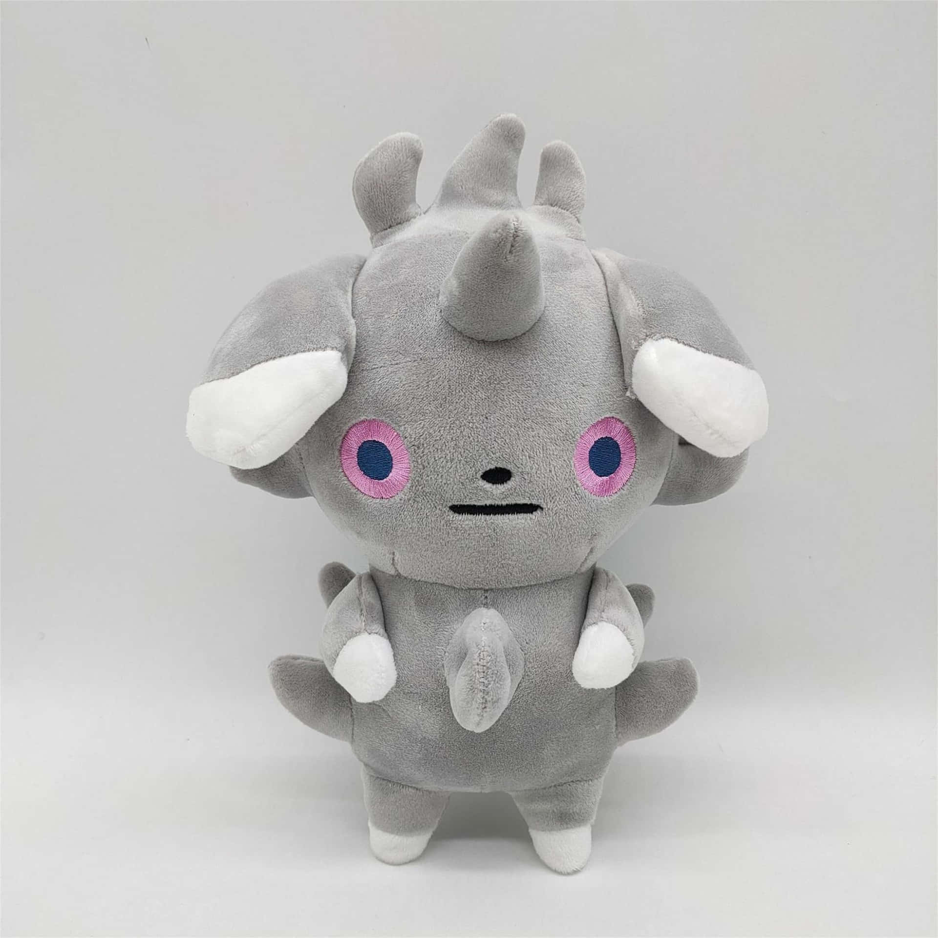 一隻灰色的 Pokémon 鐵甲犀牛毛絨玩具，擁有粉紅色眼睛和白色點綴。