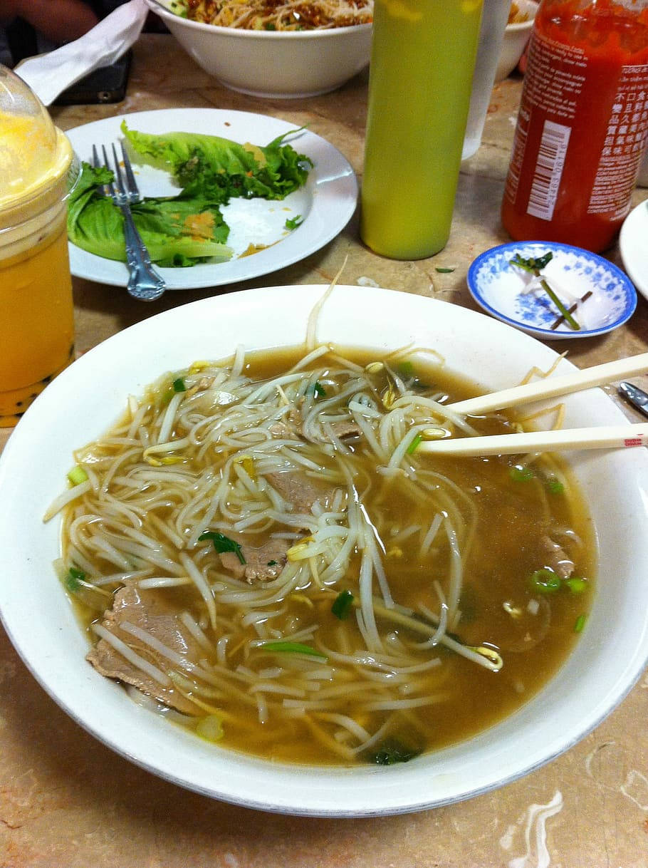 桌上的一碗麵條湯，配有豆芽和肉。
