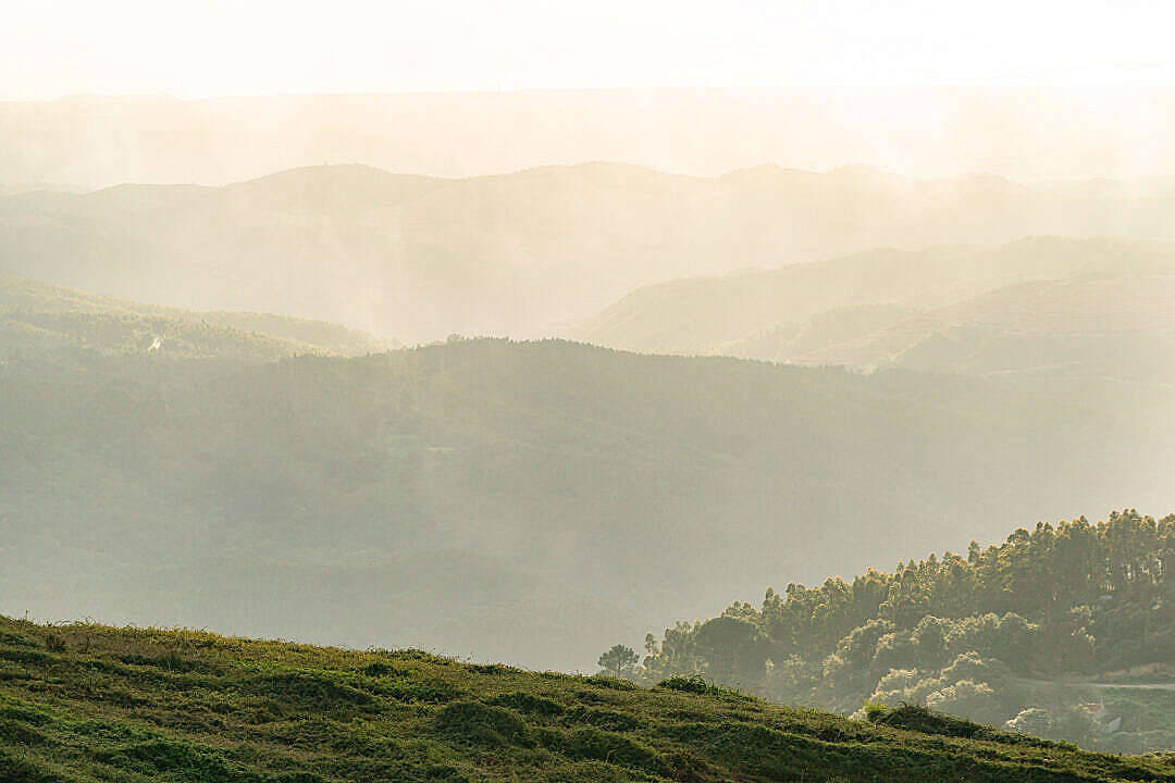 寧靜的山景，薄霧和陽光穿過樹林。