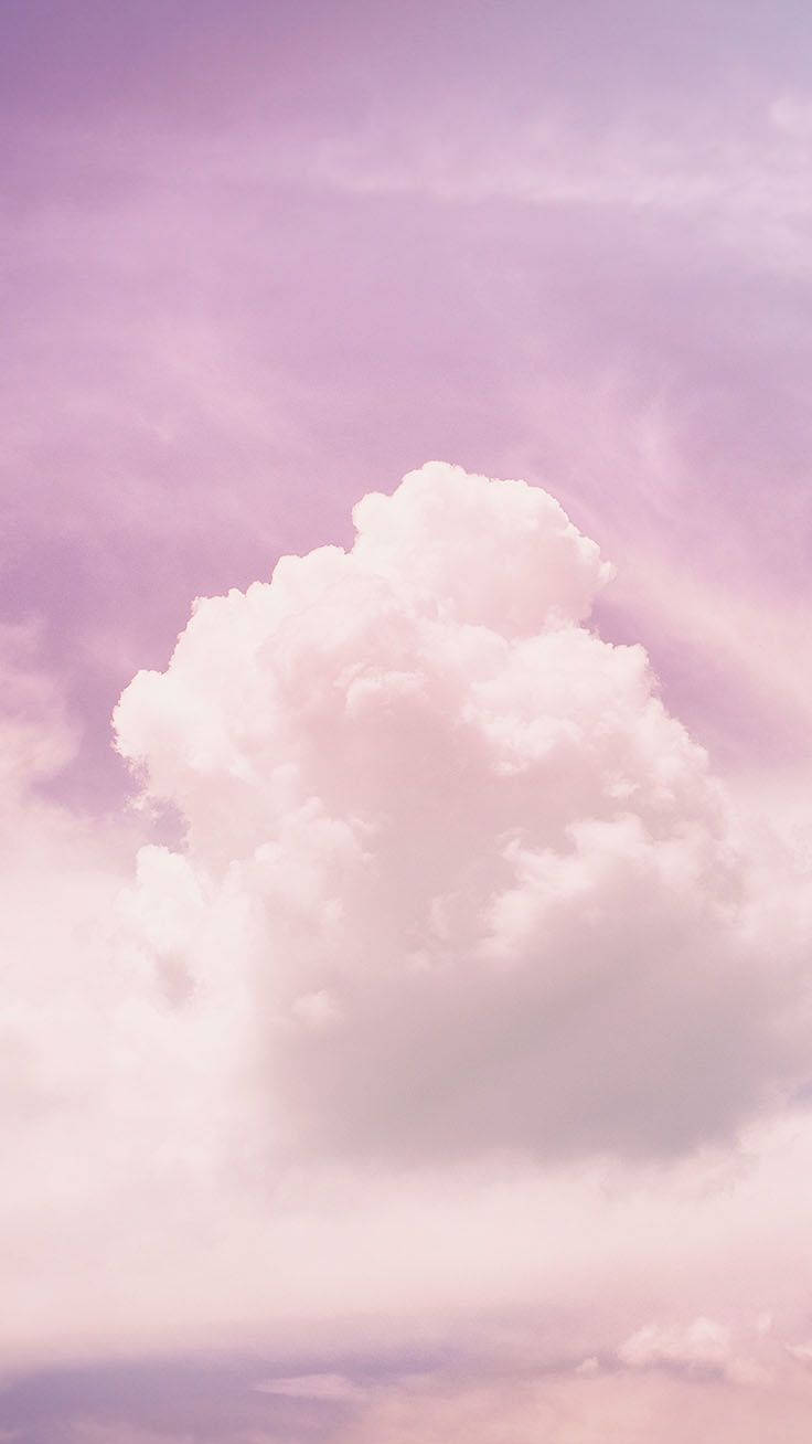 在柔和粉彩色的薰衣草天空中，一朵巨大的蓬鬆白雲。