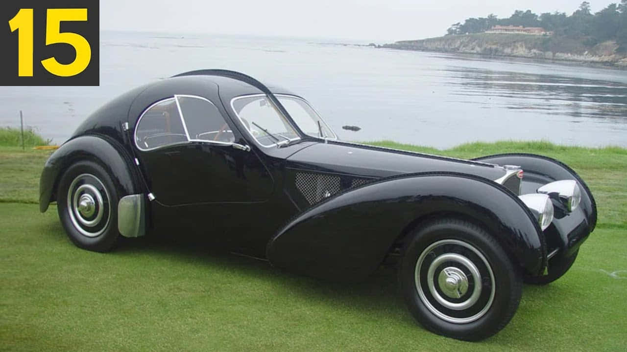黑色復古Bugatti跑車停泊在近海的草地上。