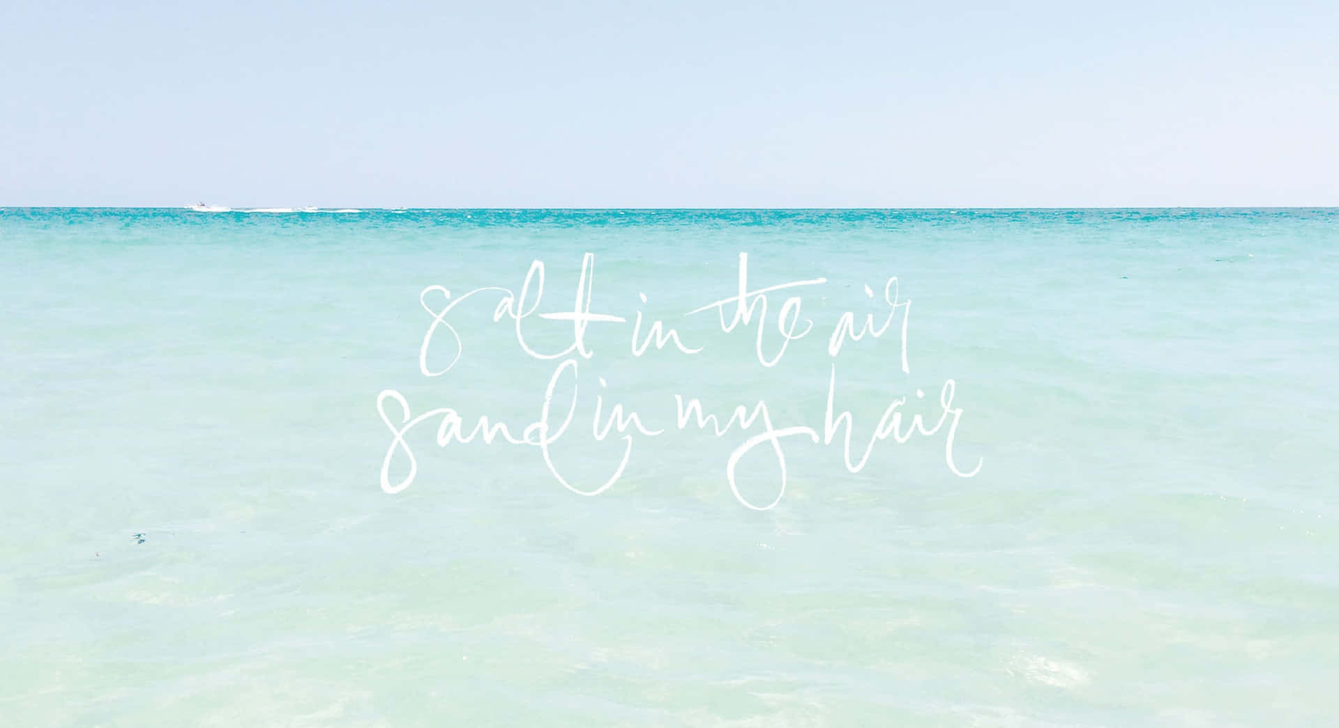 平靜的藍綠色海洋上白色字體寫著 salt in the air sand in my hair。
