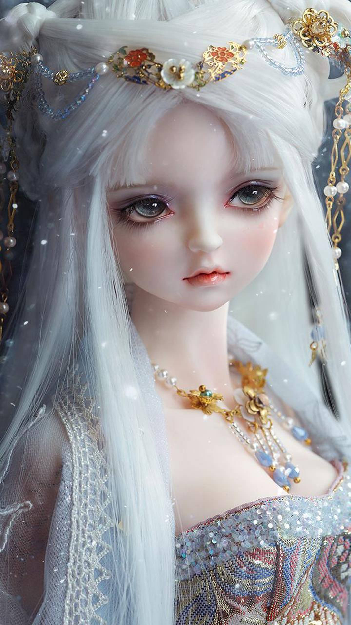 迷人魔法女玩偶 壁紙 — 一個動漫風格娃娃的特寫，長長的白髮飾有金和珍珠首飾，在柔和燈光下穿著閃閃發光的禮服。