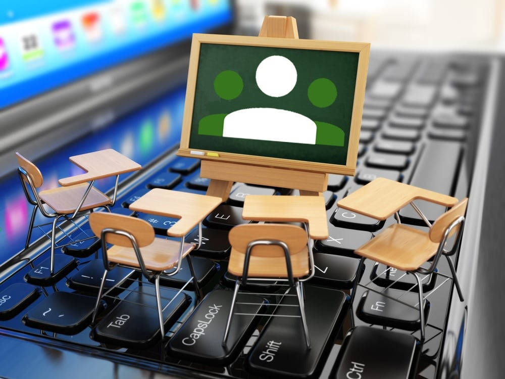 迷你教室與 Google Classroom 標誌 壁紙 — 一個小型教室，配有書桌和黑板，放在電腦鍵盤上，象徵網上學習。