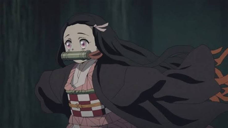迷你祢豆子 前往鬼滅之刃 壁紙 — 一個受驚的動漫女孩，長長的黑髮和紫色眼睛，嘴裡含著竹管，背景是黑暗的森林。