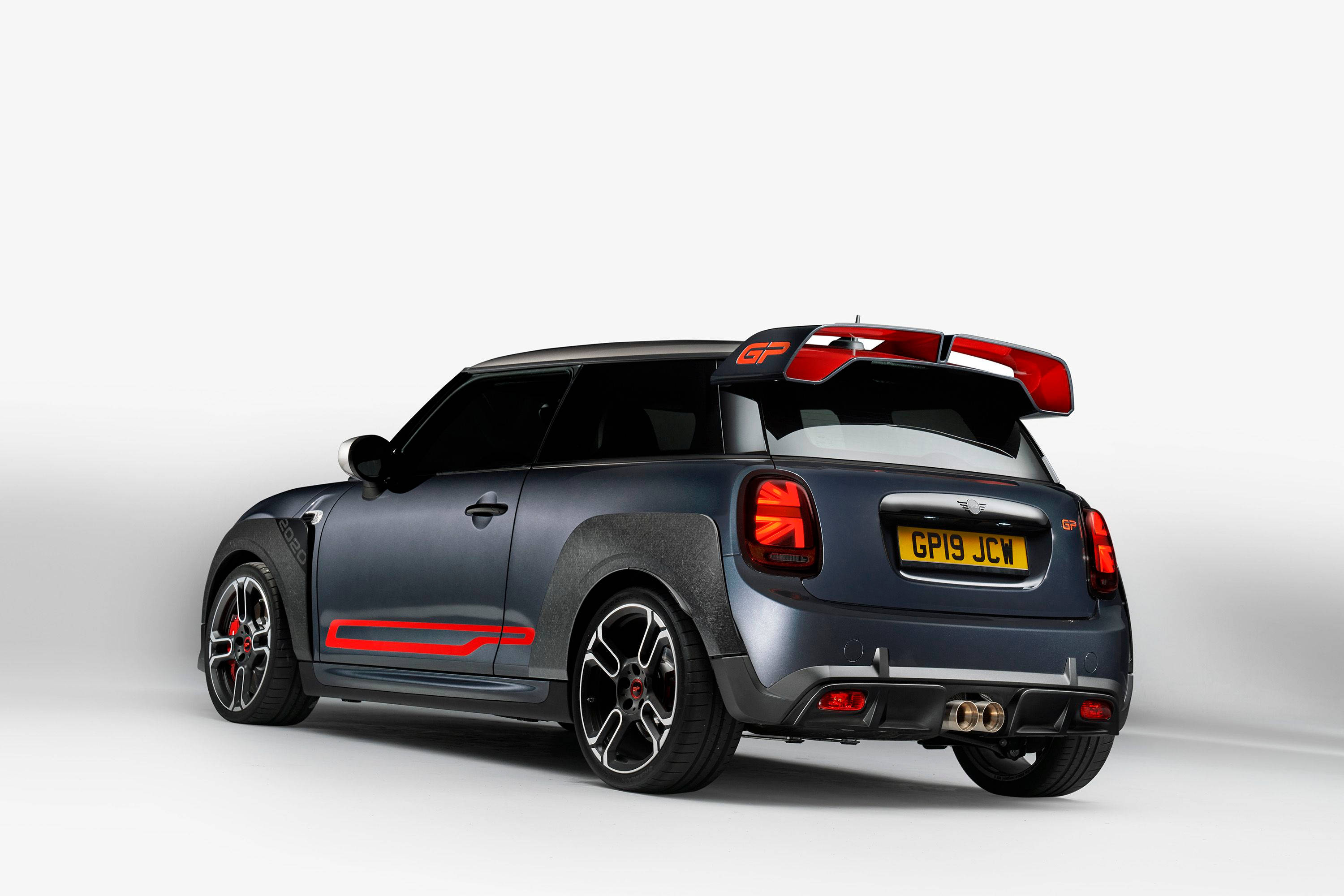 迷你黑色美學車款純白背景 壁紙 — 一架時尚的啞光黑色MINI Cooper GP，帶有紅色點綴和大型後擾流板，在潔白的攝影棚背景下蓄勢待發。