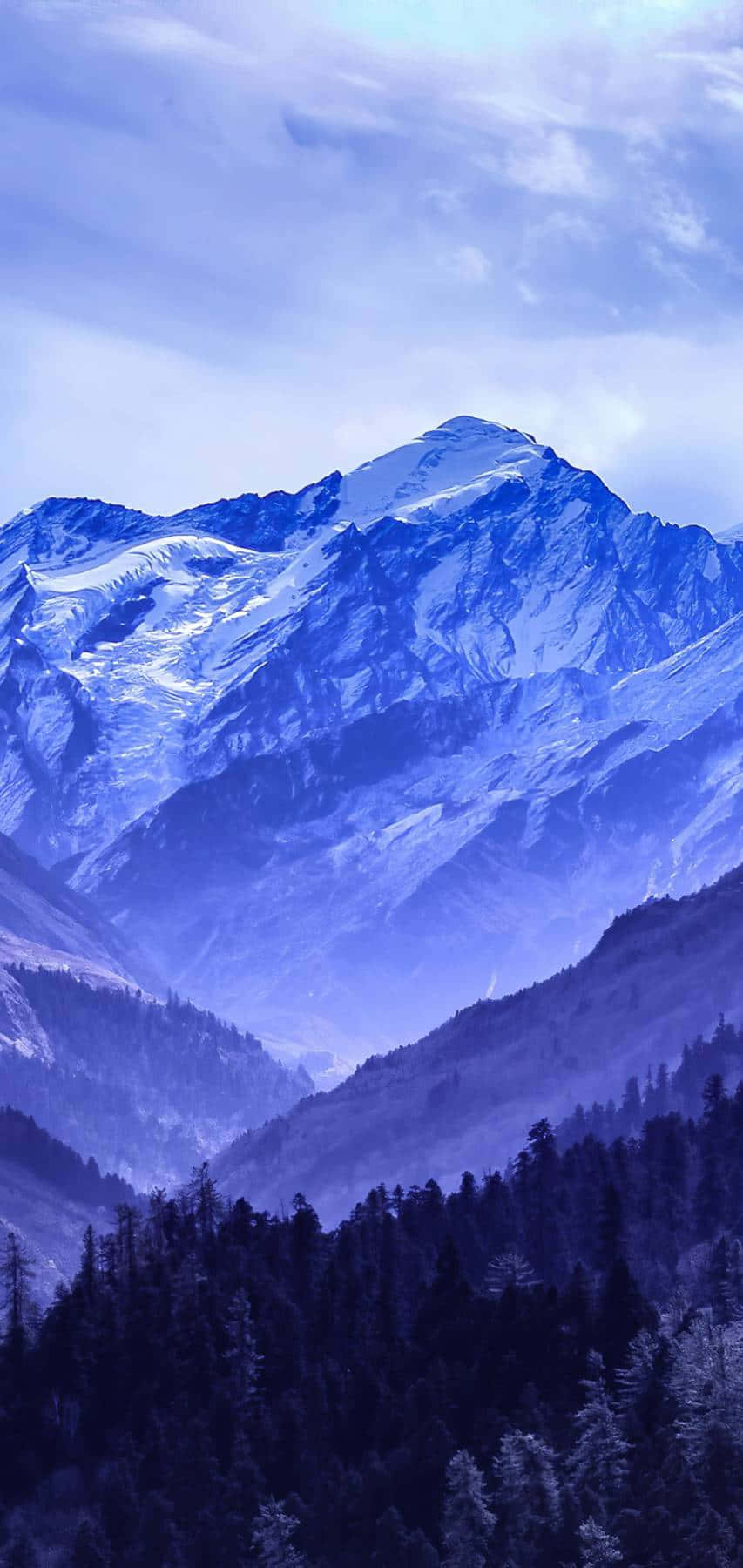 迷失在充滿想像力與抽象夢境的神秘藍色世界 壁紙 — 雄偉的雪山山脈沐浴在清涼的藍光中，下方是茂密的常綠森林。