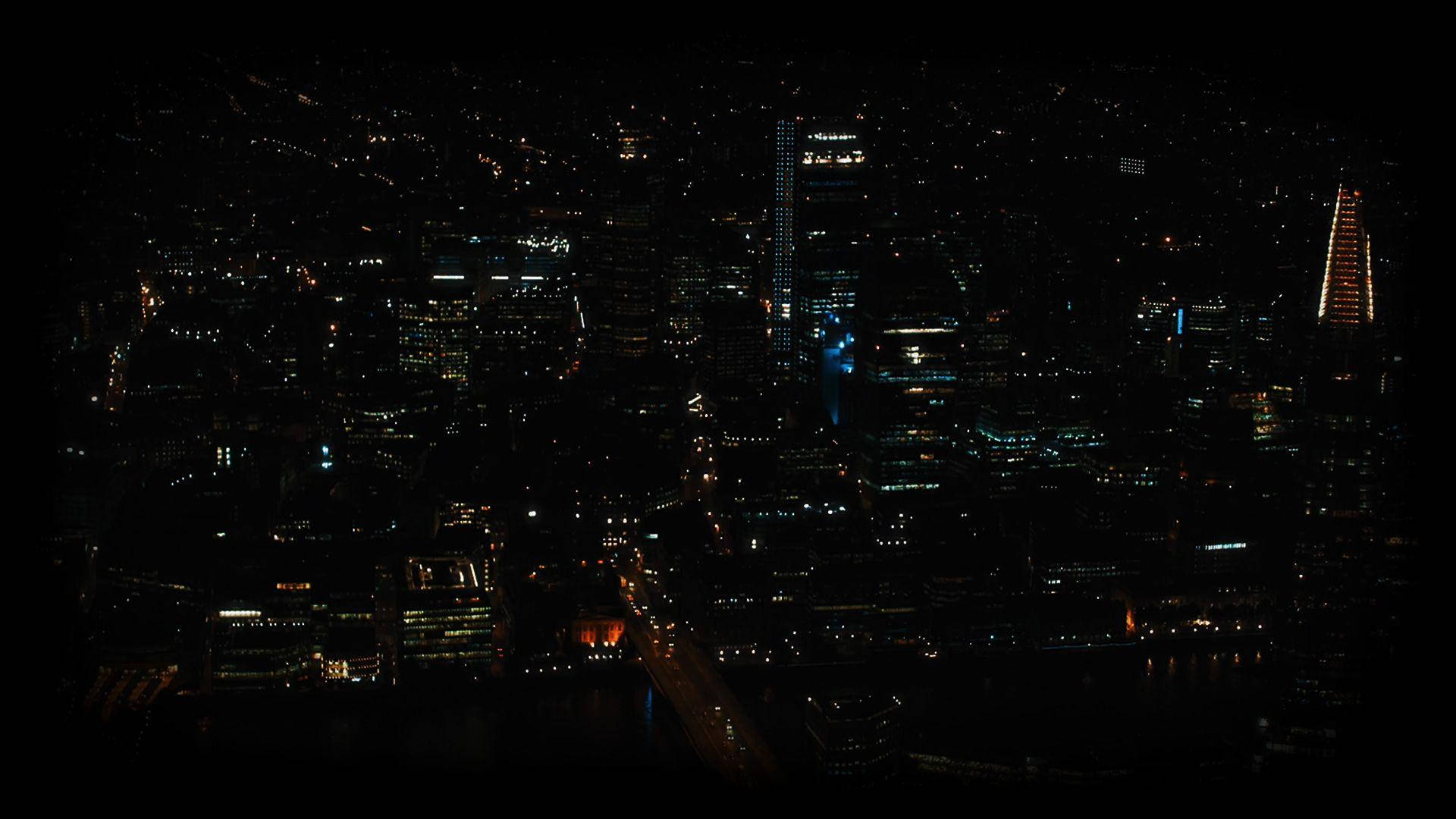 迷幻暗黑夜景城市 壁紙 — 密集城市景觀的夜間鳥瞰圖，無數發光的窗戶和街燈在黑暗的天空下照亮。
