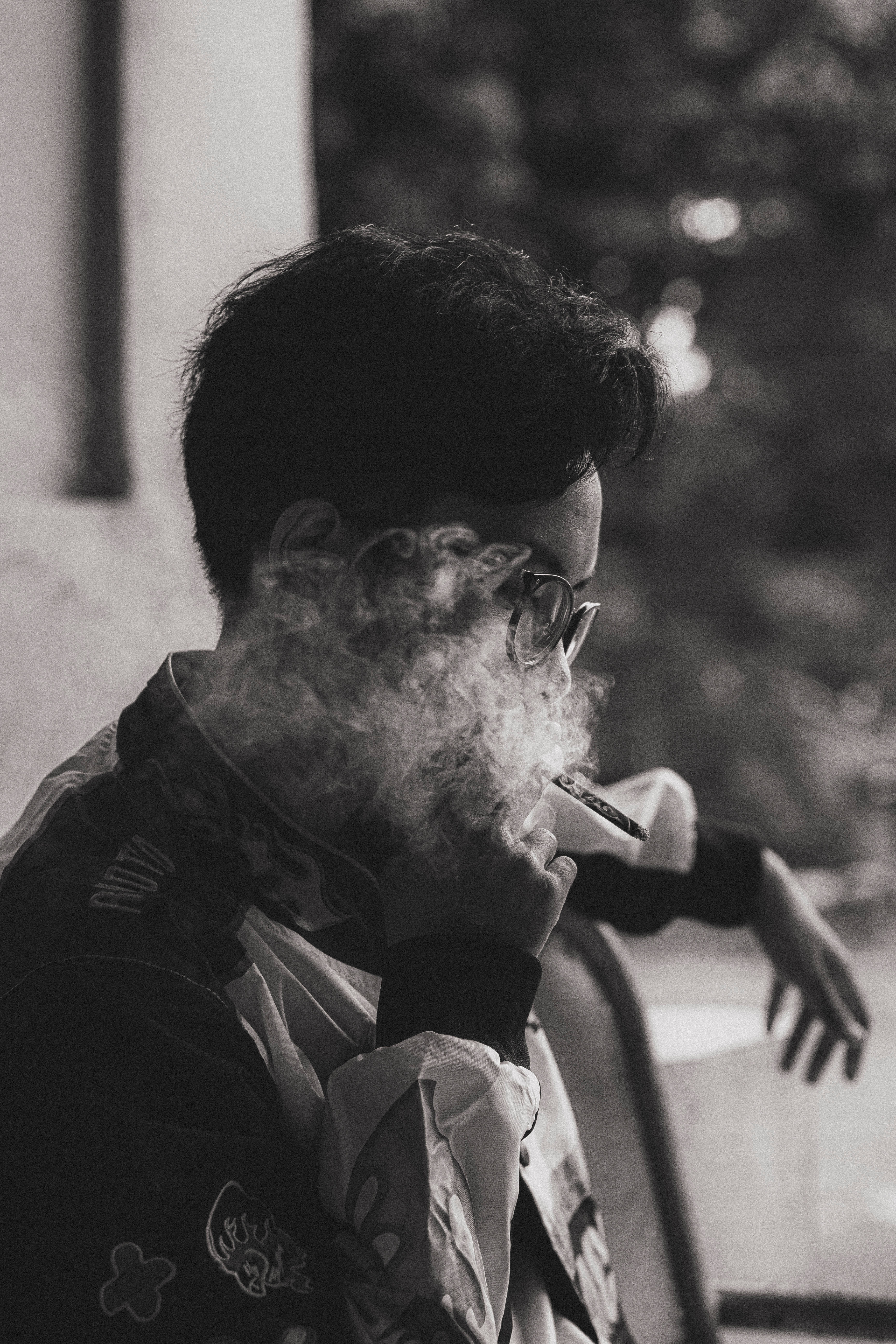迷幻風格抽菸男子 壁紙 — 一個戴眼鏡嘅人喺一張充滿氣氛嘅黑白肖像中，手持電子煙筆呼出濃煙。