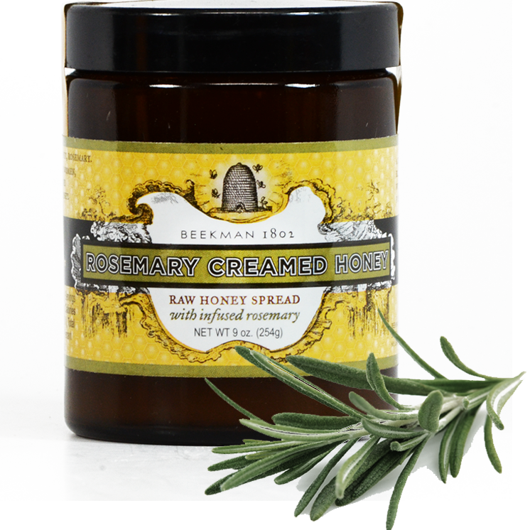 迷迭香奶油蜂蜜罐 壁紙 — 一個 Beekman 1802 迷迭香忌廉蜂蜜罐，旁邊有新鮮迷迭香枝，放在白色表面上。