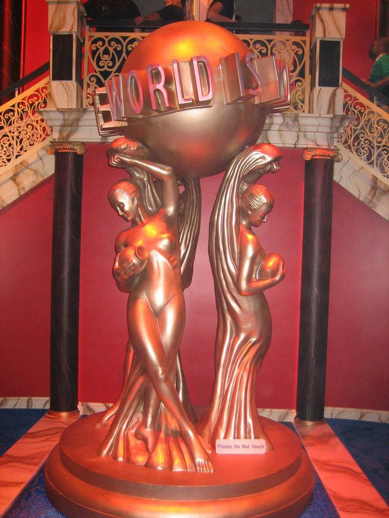 銅像在劇院大廳中手持帶有「WORLD」字樣的地球儀。