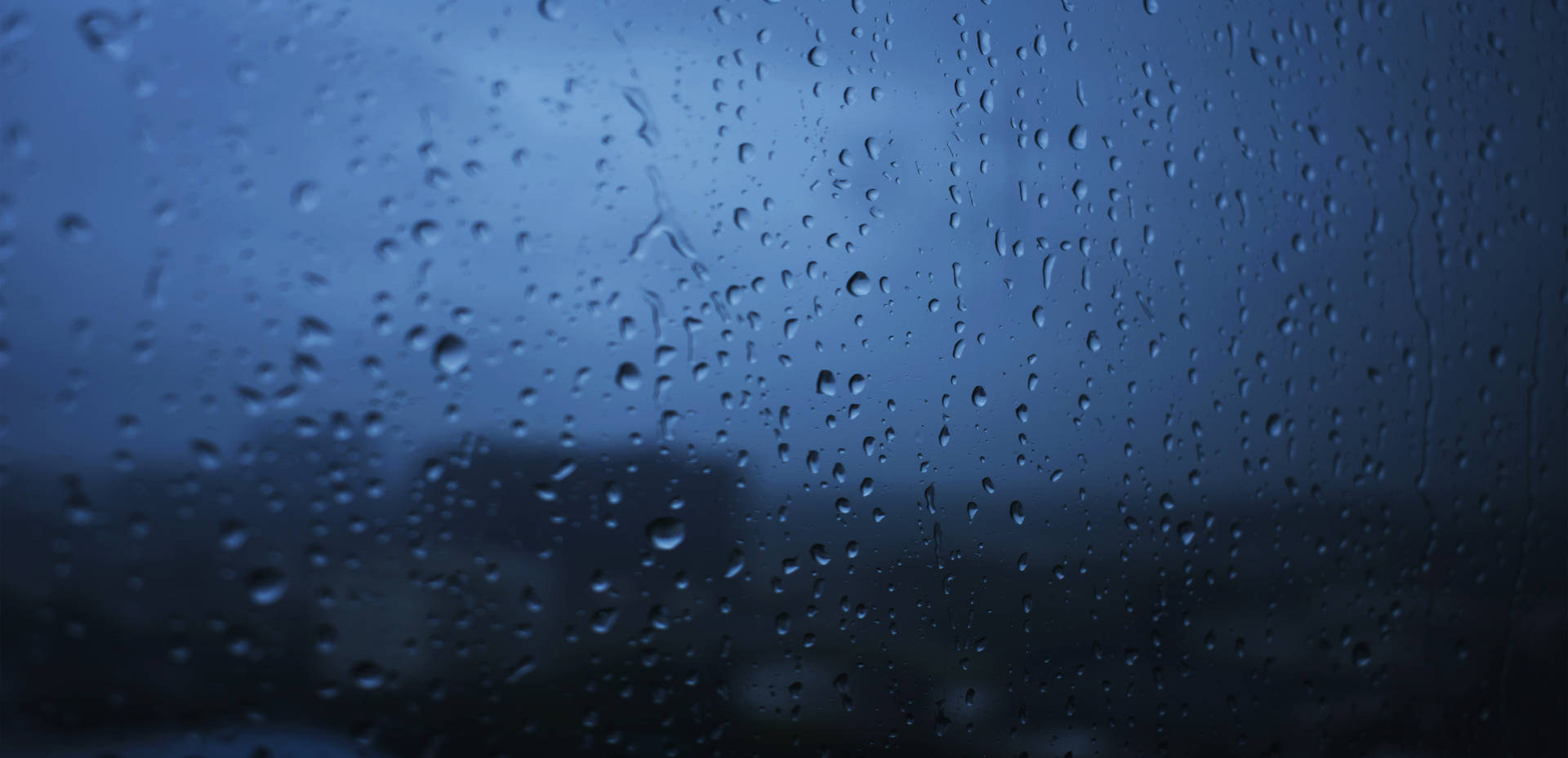 窗戶上的雨滴，俯瞰夜晚的黑暗城市。